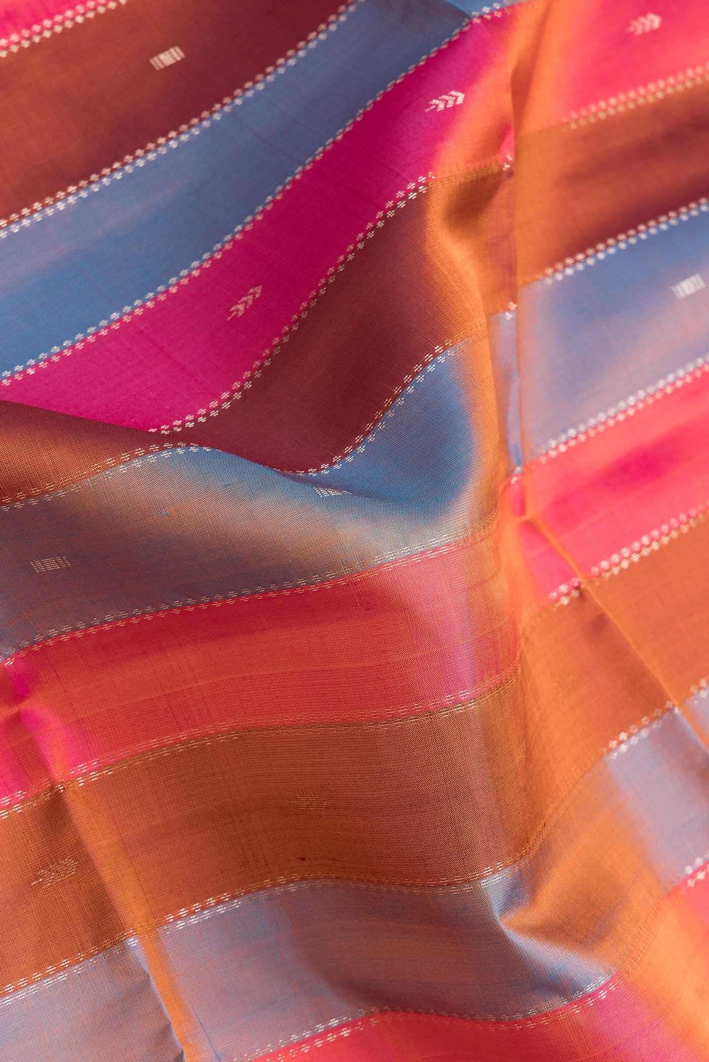 Close up of Pink, Brown and Peacock Blue Color Soft Silk Saree with Stripes on the body and Without Border.  displaying folds
