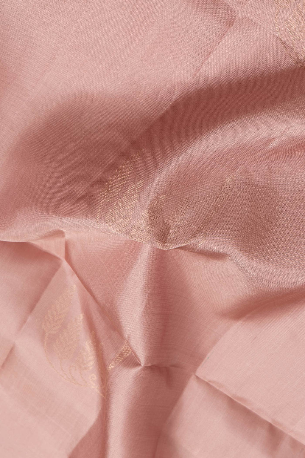 Close up of Rose Gold Dual Tone Soft Silk Saree with Zari Butta on the body and Zari Border.  displaying folds