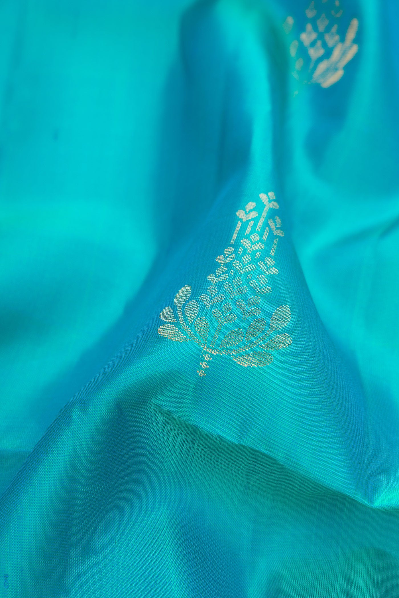 Close up of Sky Blue Dual Tone Soft Silk Saree with Zari Butta on the body and Zari Border.  displaying folds
