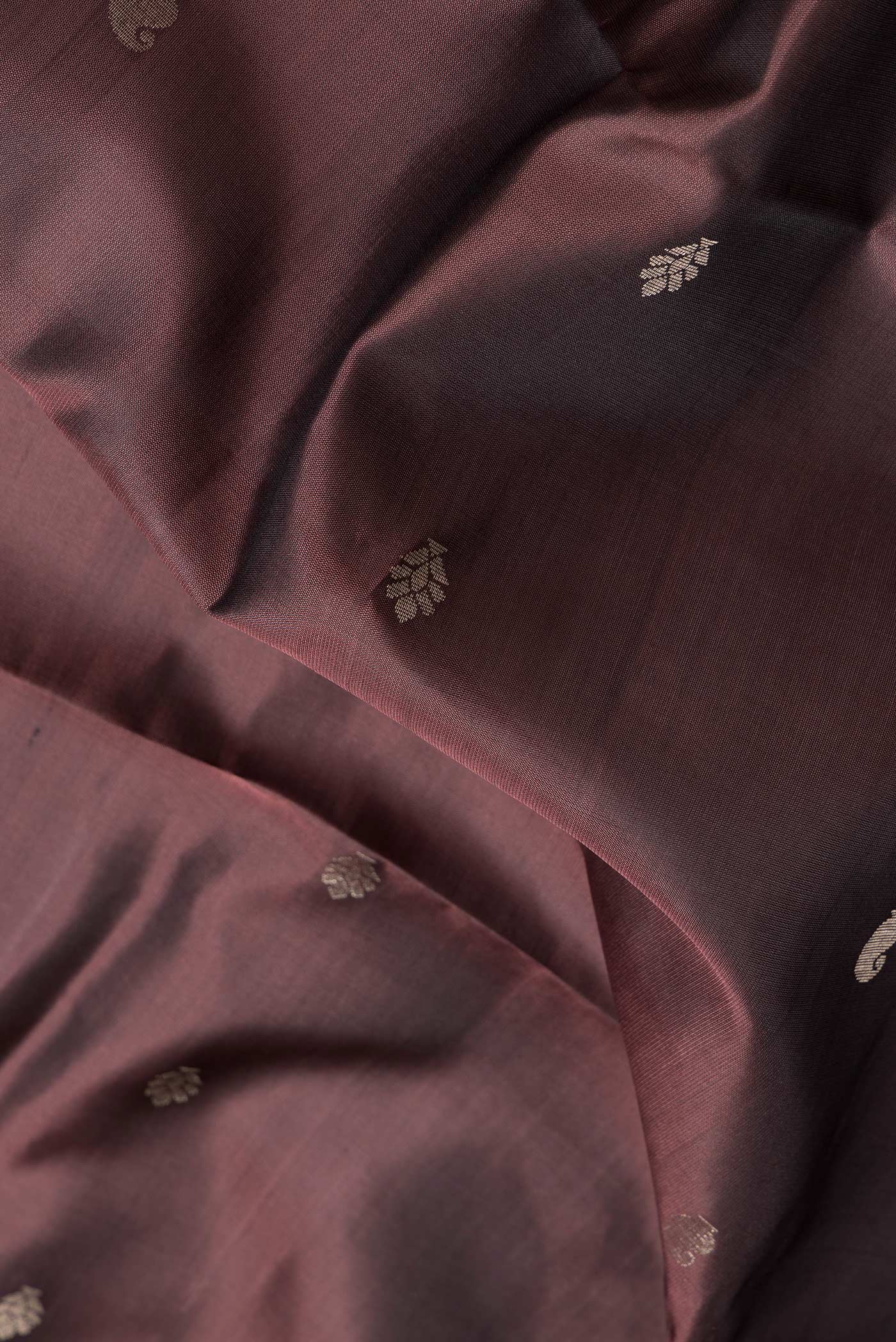 Close up of Brown Dual Tone Soft Silk Saree with Zari Butta on the body and Zari Border.  displaying folds