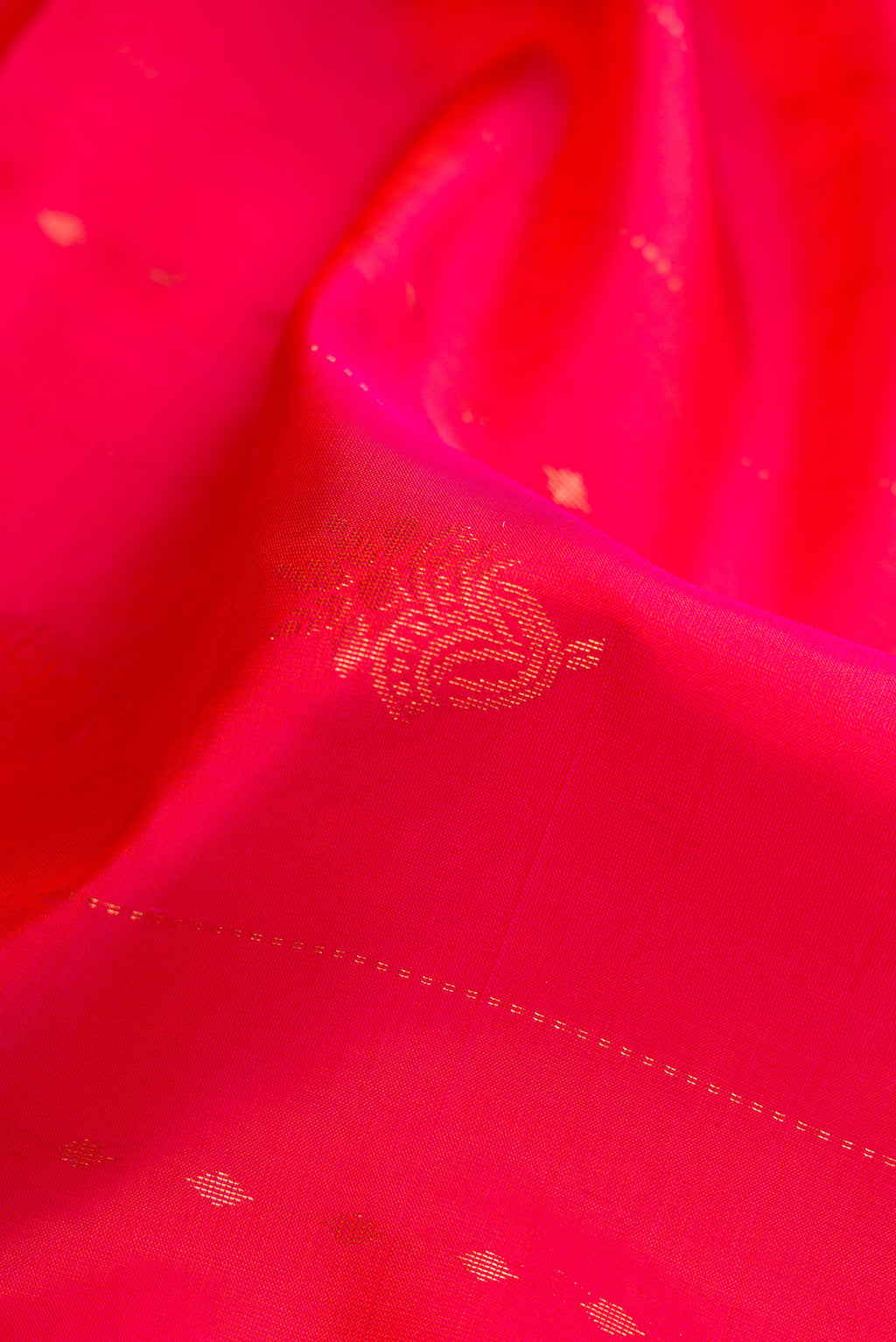 Close up of Coral Dual Tone Soft Silk Saree with Zari Butta on the body and Fancy Border.  displaying folds