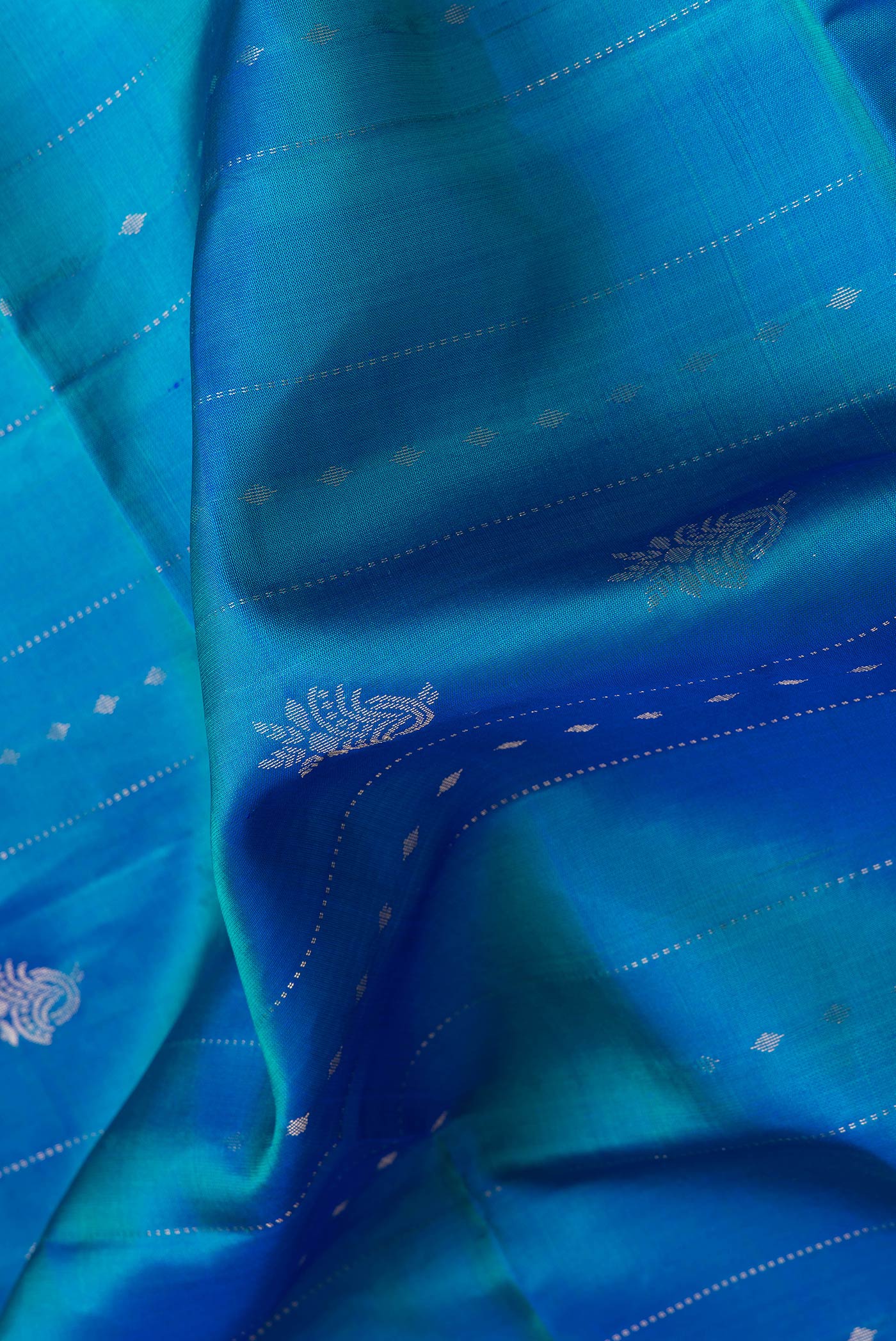 Close up of Peacock Blue Dual Tone Soft Silk Saree with Stripes on the body and Fancy Border.  displaying folds
