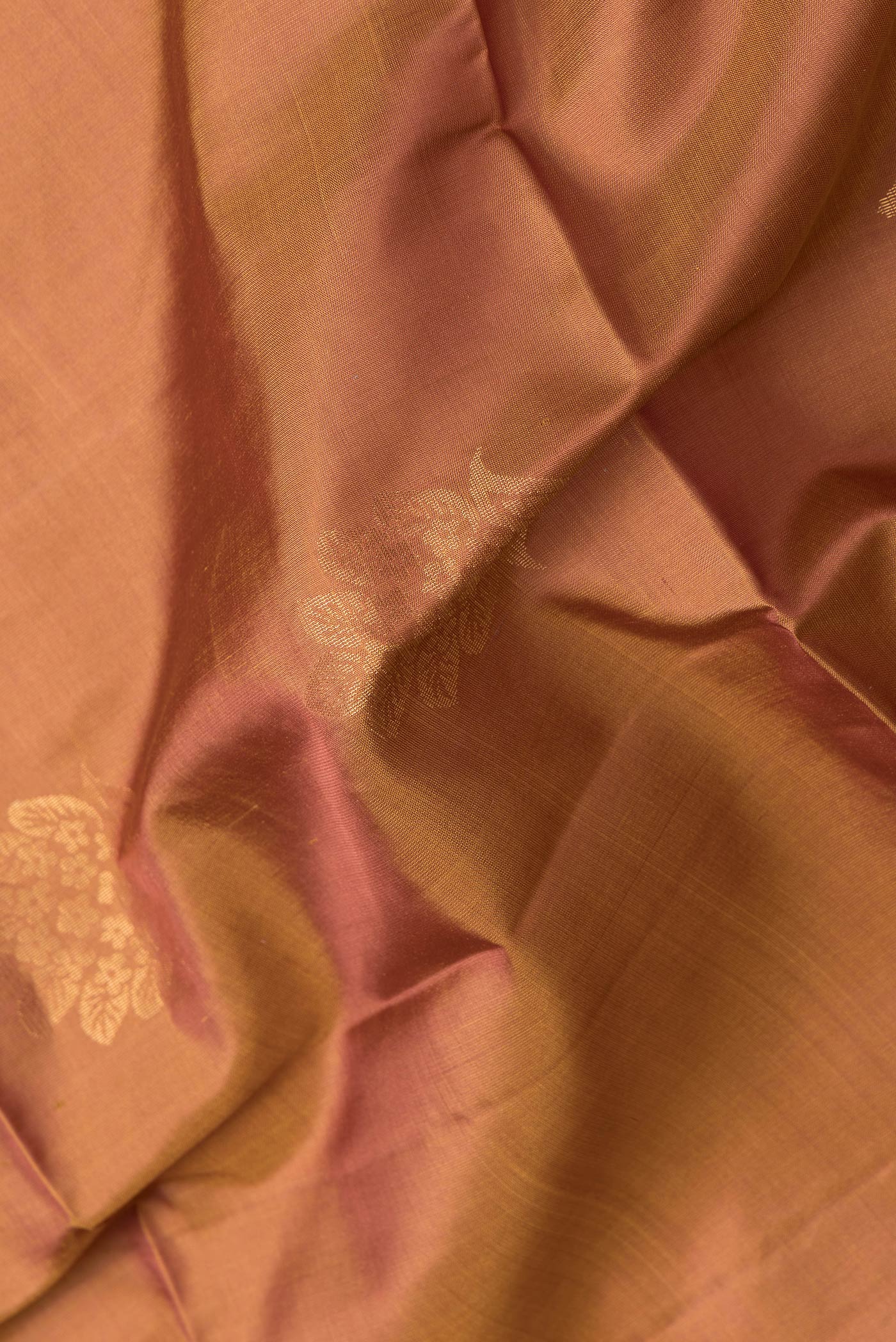 Close up of Gold Dual Tone Soft Silk Saree with Zari Butta on the body and Without Border.  displaying folds