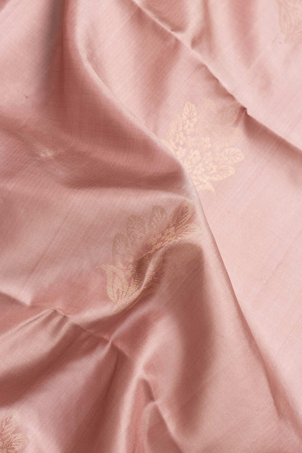 Close up of Rose Gold Dual Tone Soft Silk Saree with Zari Butta on the body and Without Border.  displaying folds