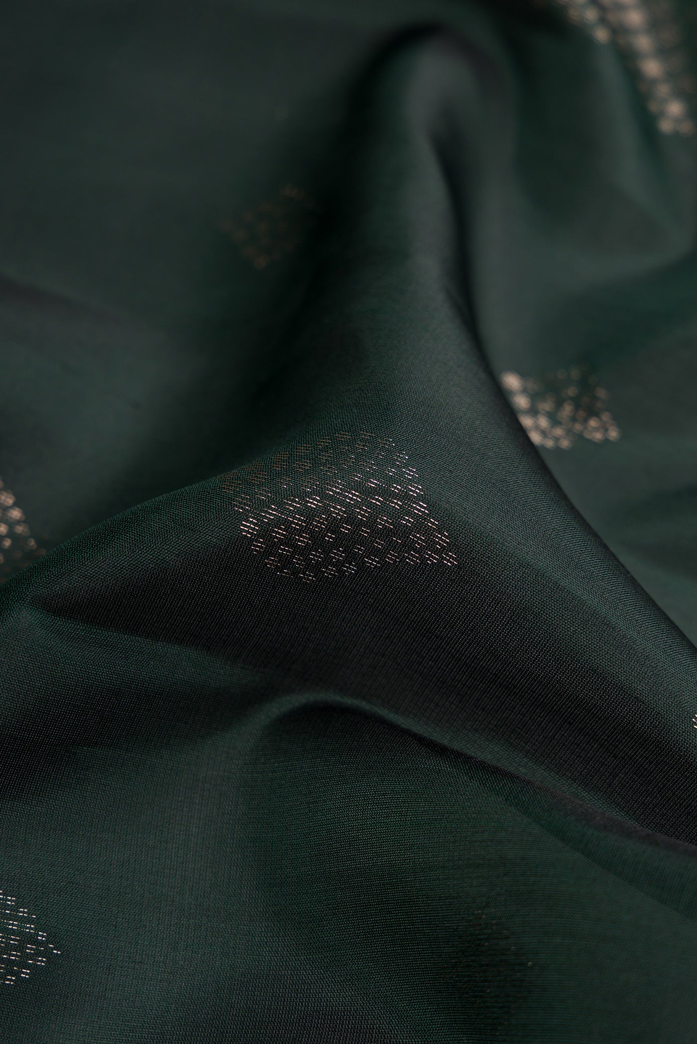Close up of Bottle Green Dual Tone Soft Silk Saree with Zari Butta on the body and Zari Border.  displaying folds