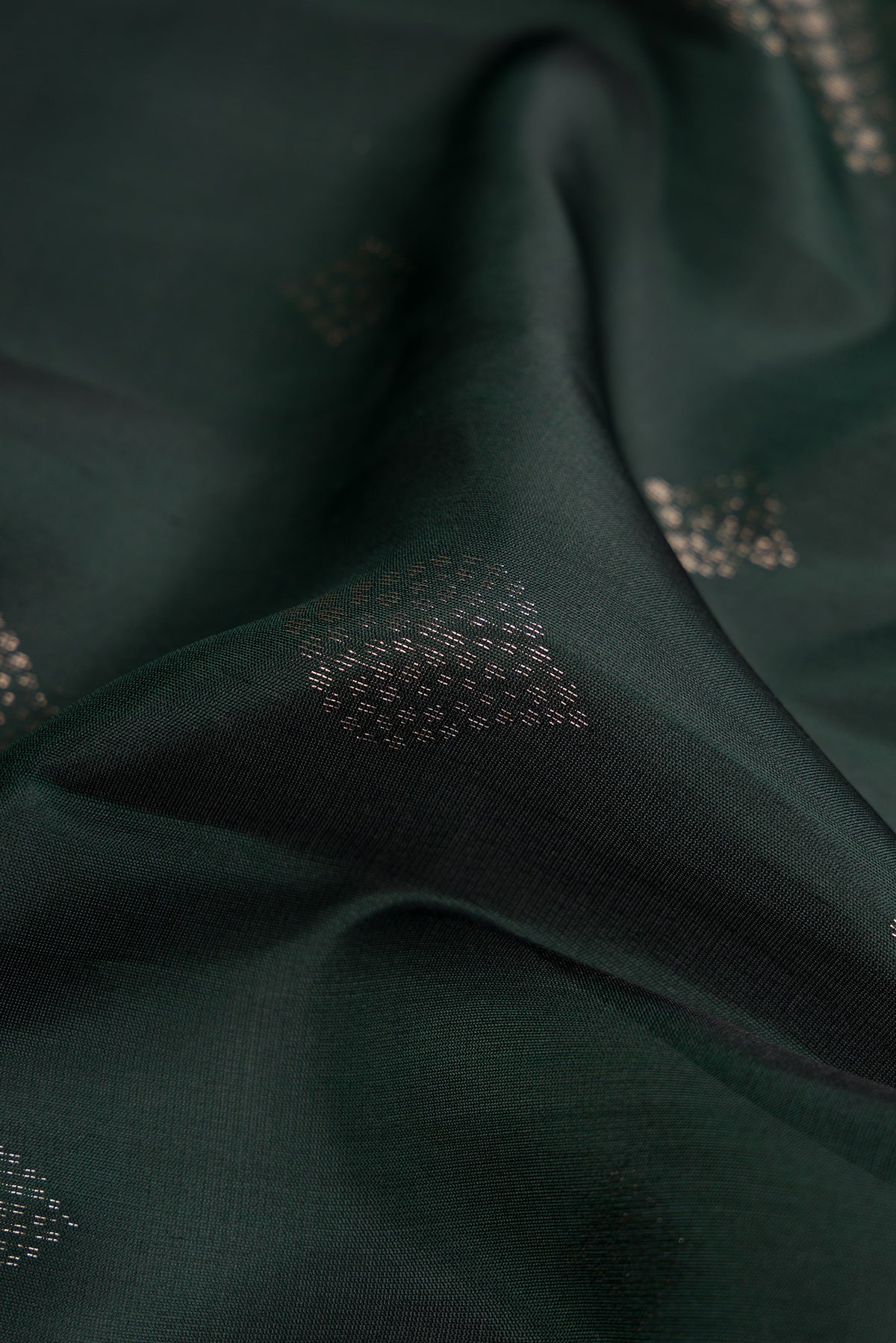 Close up of Bottle Green Dual Tone Soft Silk Saree with Zari Butta on the body and Zari Border.  displaying folds