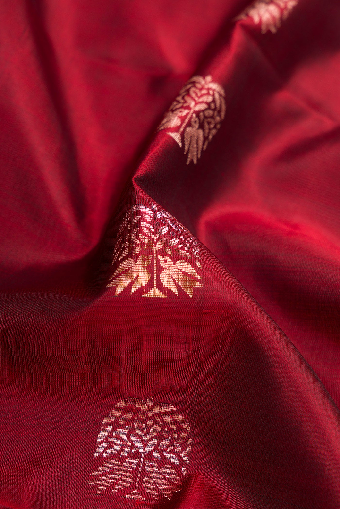 Close up of Maroon Dual Tone Soft Silk Saree with Zari Butta on the body and Zari Border.  displaying folds