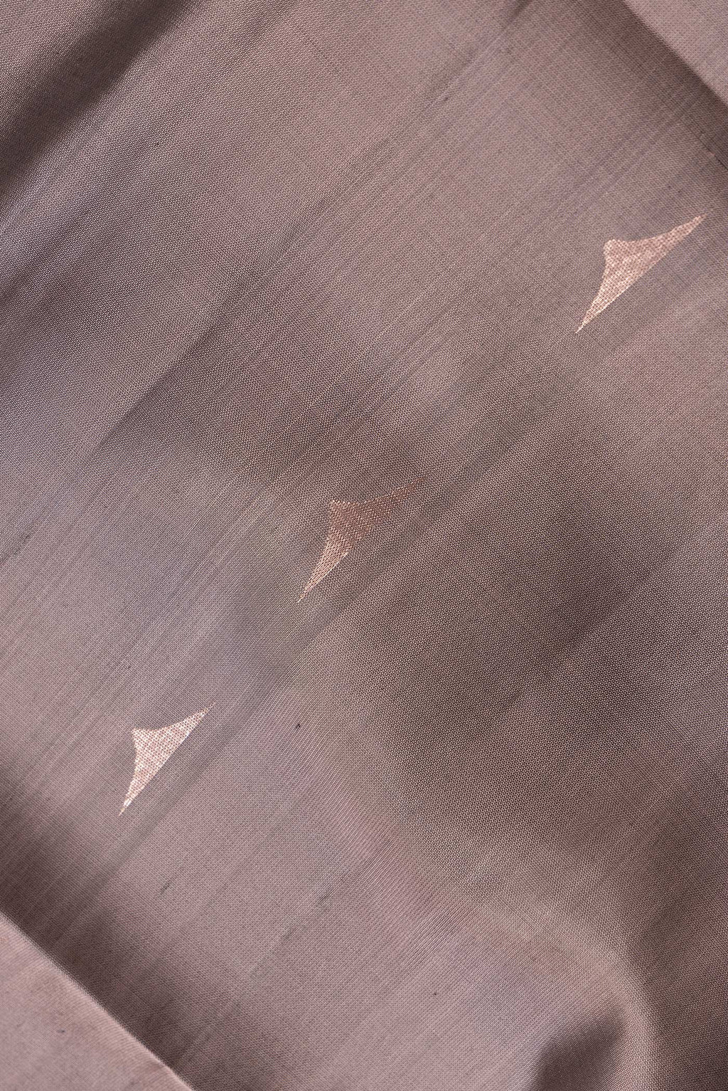 Close up of Brown Dual Tone Soft Silk Saree with Zari Butta on the body and Zari Border.  displaying folds