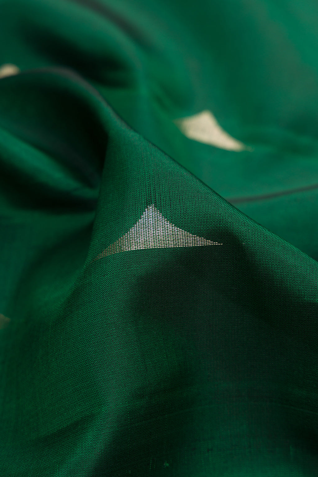 Close up of Green Dual Tone Soft Silk Saree with Zari Butta on the body and Zari Border.  displaying folds