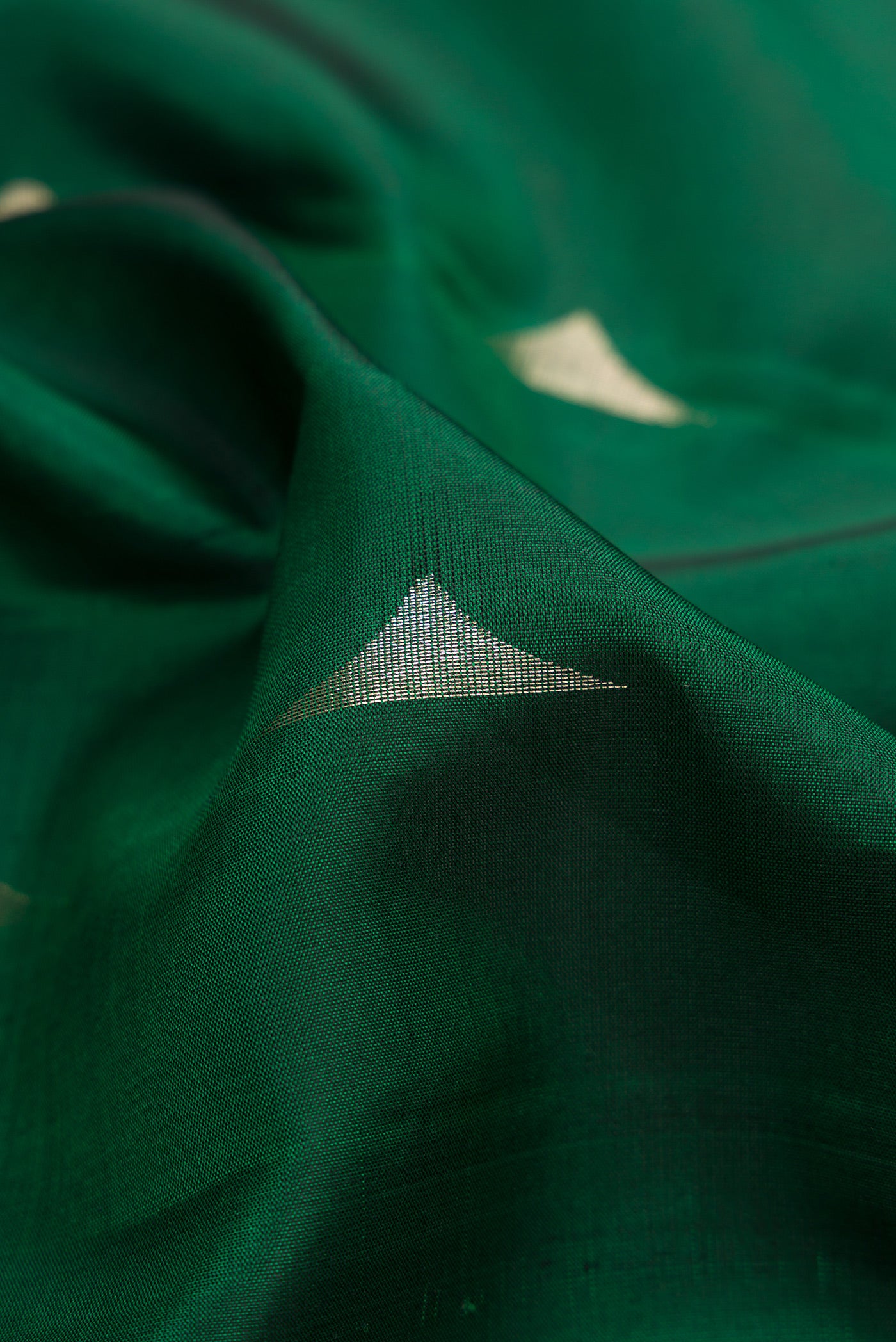 Close up of Green Dual Tone Soft Silk Saree with Zari Butta on the body and Zari Border.  displaying folds