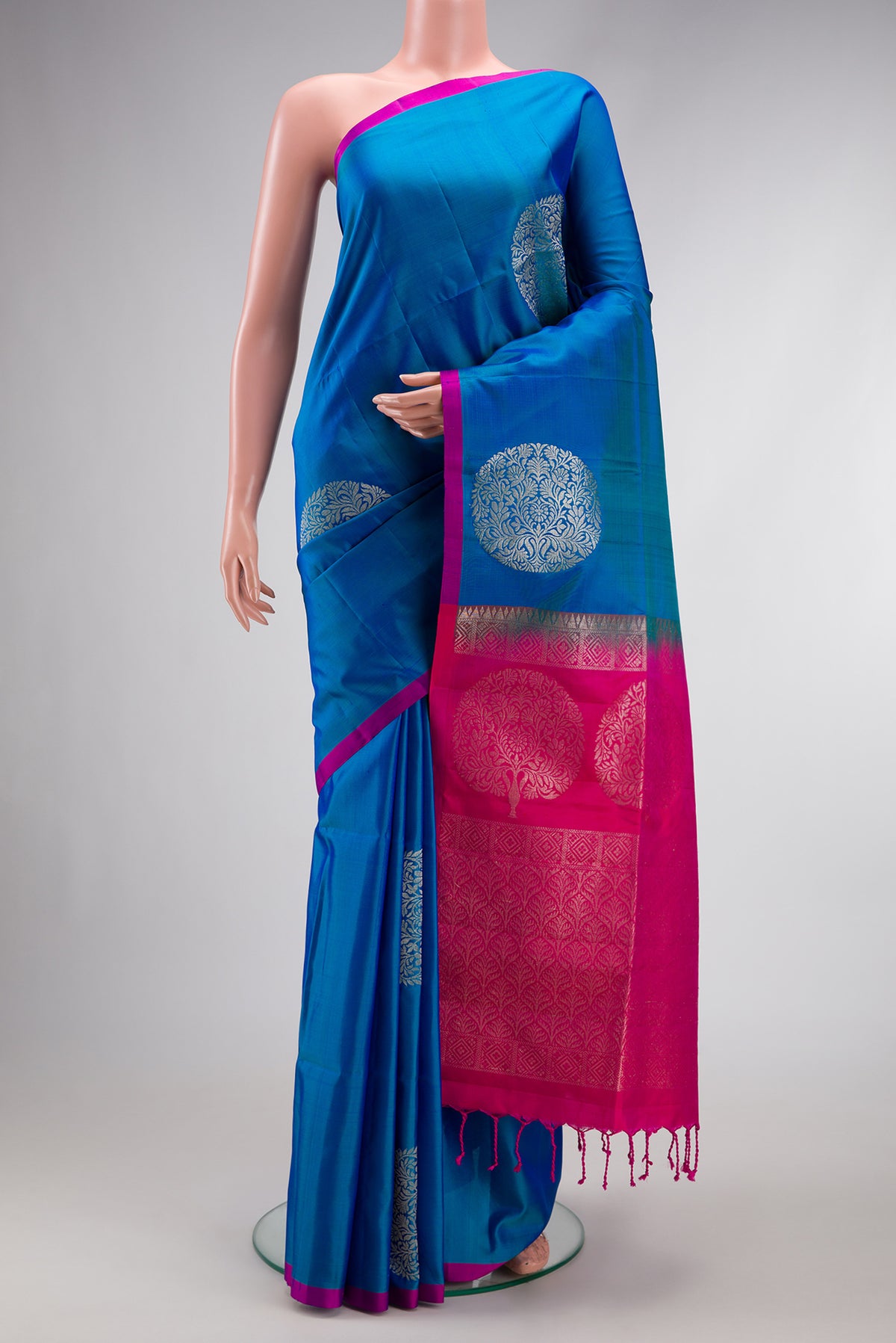 Peacock Blue Dual Tone Soft Silk Saree with Zari Butta on the body and Plain Border.  displayed on a mannequin