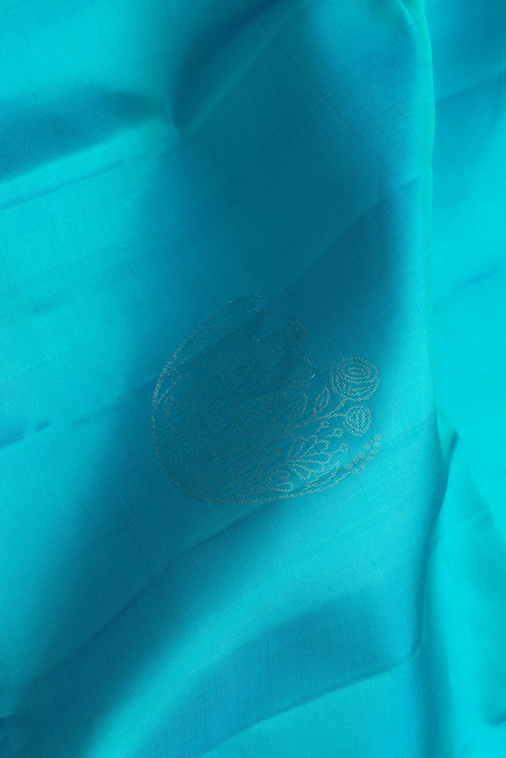 Close up of Sky Blue Dual Tone Soft Silk Saree with Zari Butta on the body and Zari Border.  displaying folds