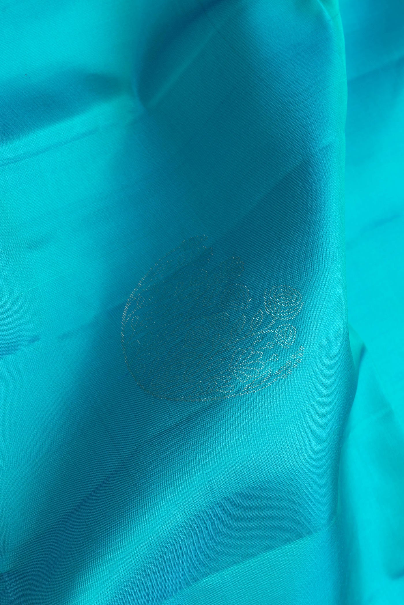 Close up of Sky Blue Dual Tone Soft Silk Saree with Zari Butta on the body and Zari Border.  displaying folds