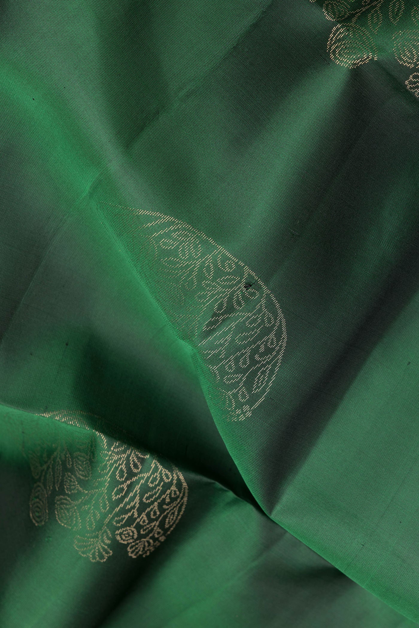 Close up of Bottle Green Soft Silk Saree with Zari Butta on the body and Zari Border.  displaying folds