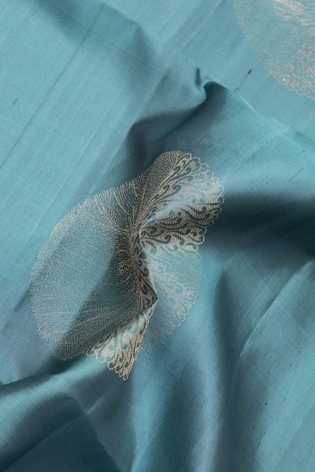 Close up of Blue Grey Soft Silk Saree with Zari Butta on the body and Zari Border.  displaying folds