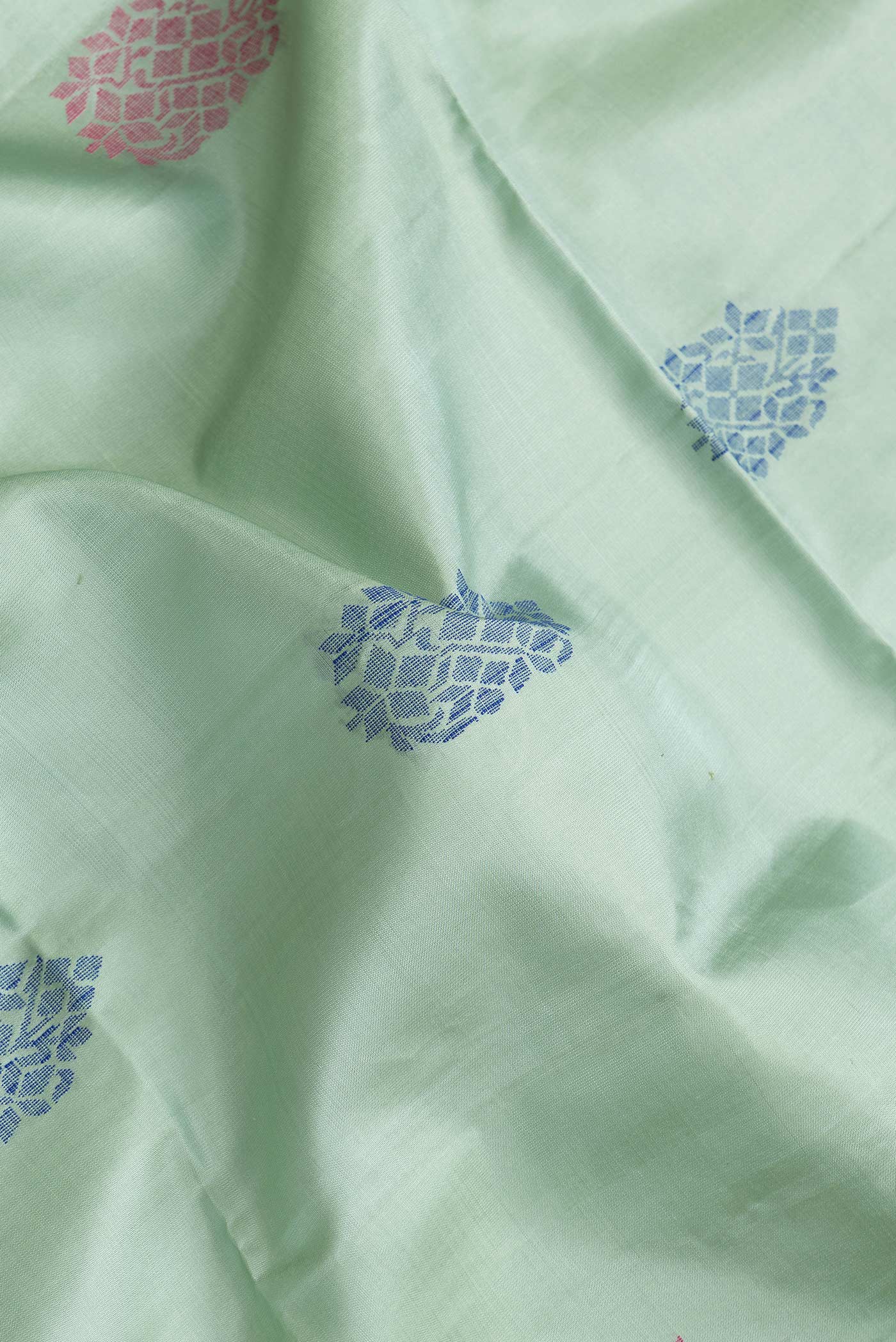 Close up of Pista Green Dual Tone Soft Silk Saree with Zari Butta on the body and Without Border.  displaying folds