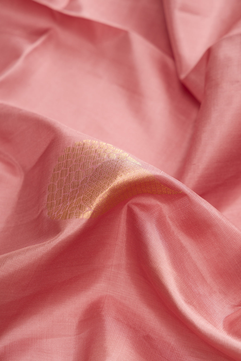 Close up of Rose Gold Dual Tone Soft Silk Saree with Zari Butta on the body and Zari Border.  displaying folds