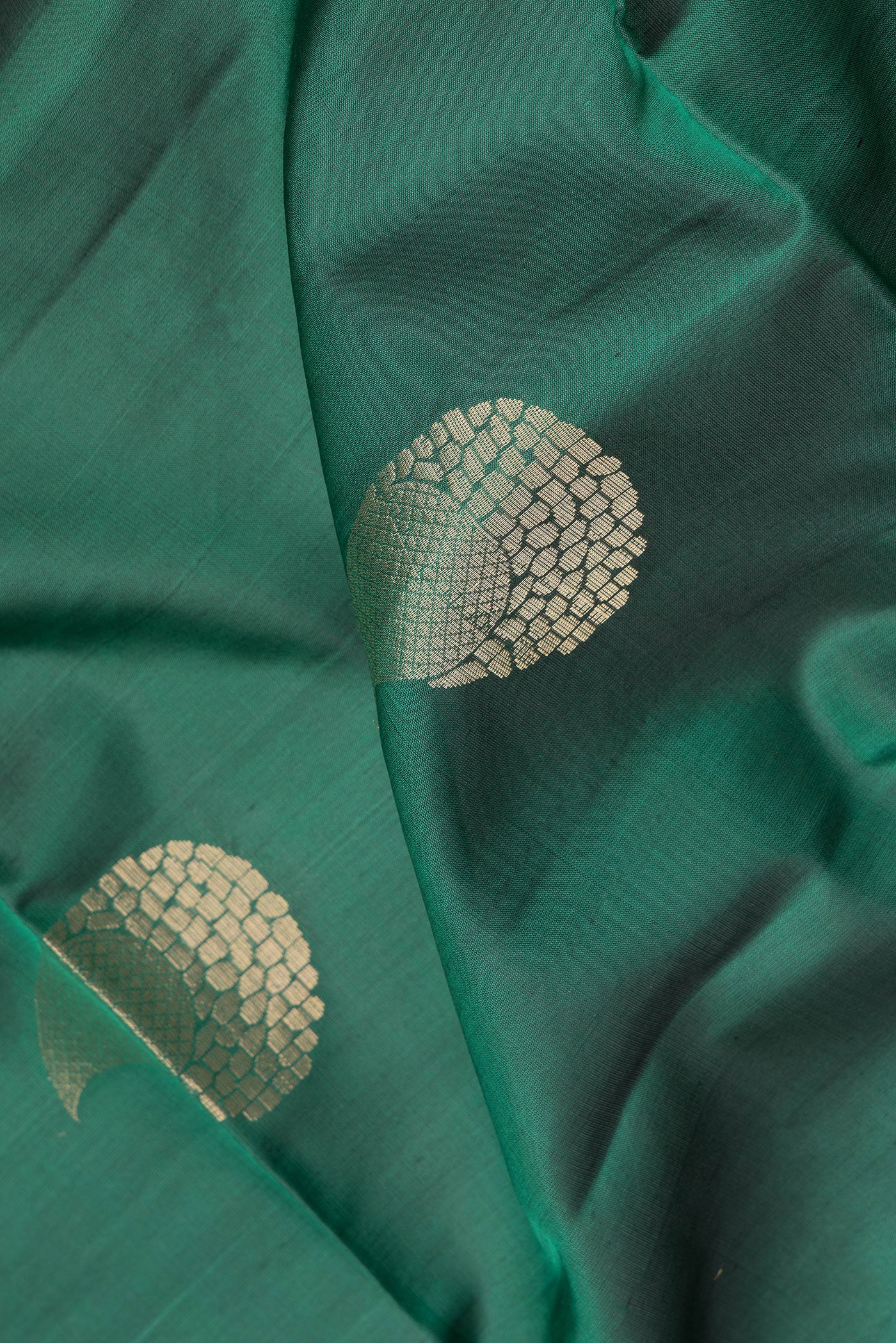 Close up of Green Soft Silk Saree with Zari Butta on the body and Zari Border.  displaying folds