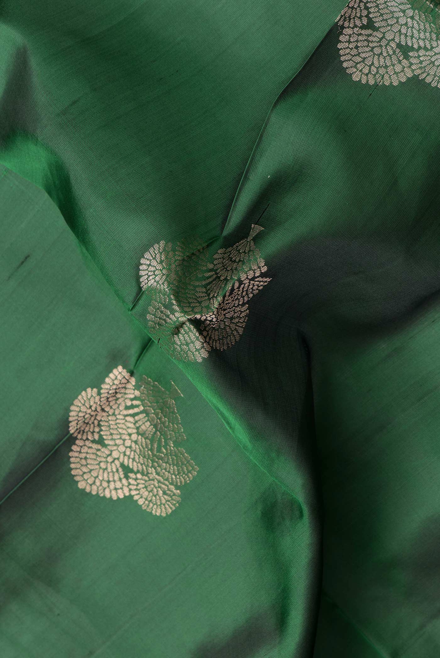 Close up of Bottle Green Dual Tone Soft Silk Saree with Zari Butta on the body and Zari Border.  displaying folds