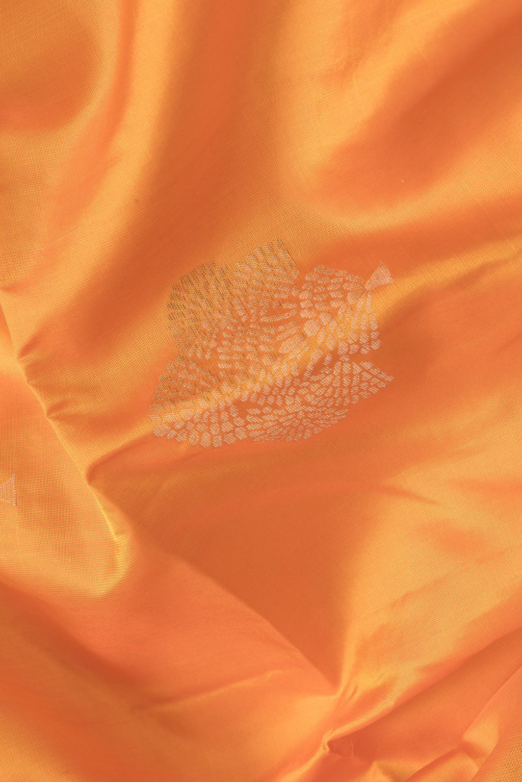 Close up of Orange Dual Tone Soft Silk Saree with Zari Butta on the body and Zari Border.  displaying folds