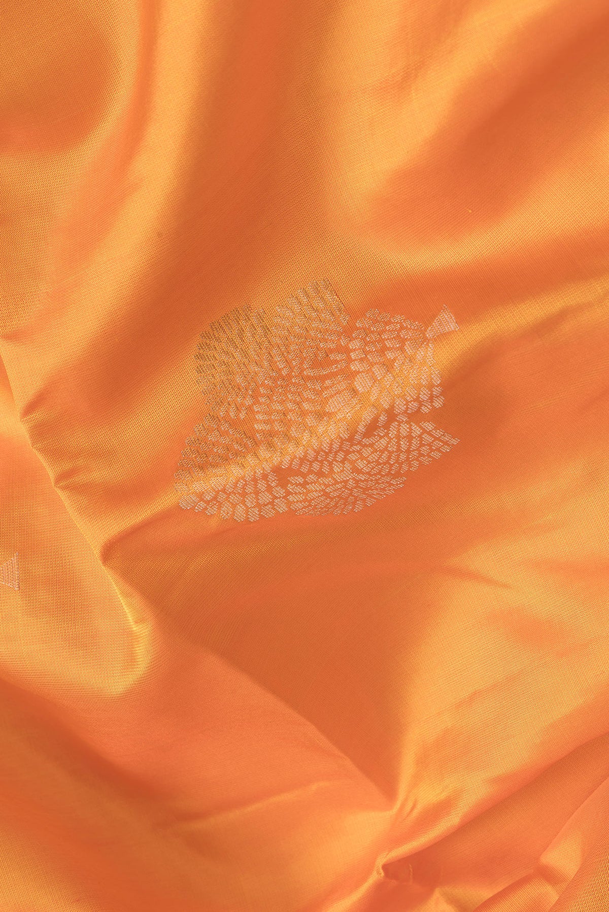Close up of Orange Dual Tone Soft Silk Saree with Zari Butta on the body and Zari Border.  displaying folds