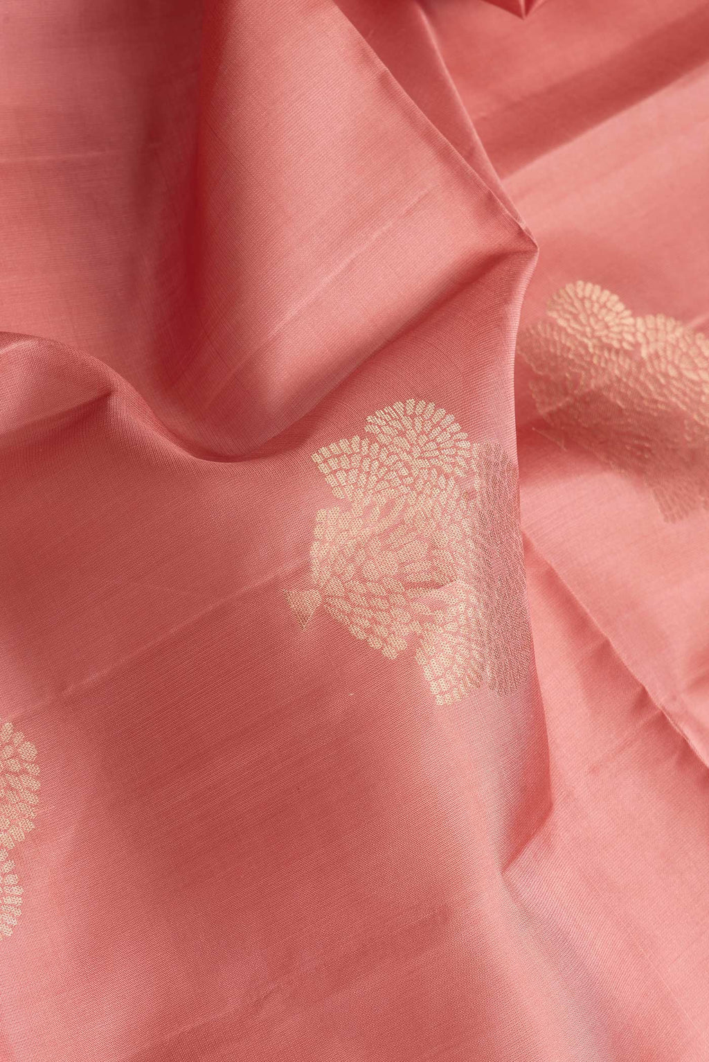Close up of Rose Gold Dual Tone Soft Silk Saree with Zari Butta on the body and Zari Border.  displaying folds