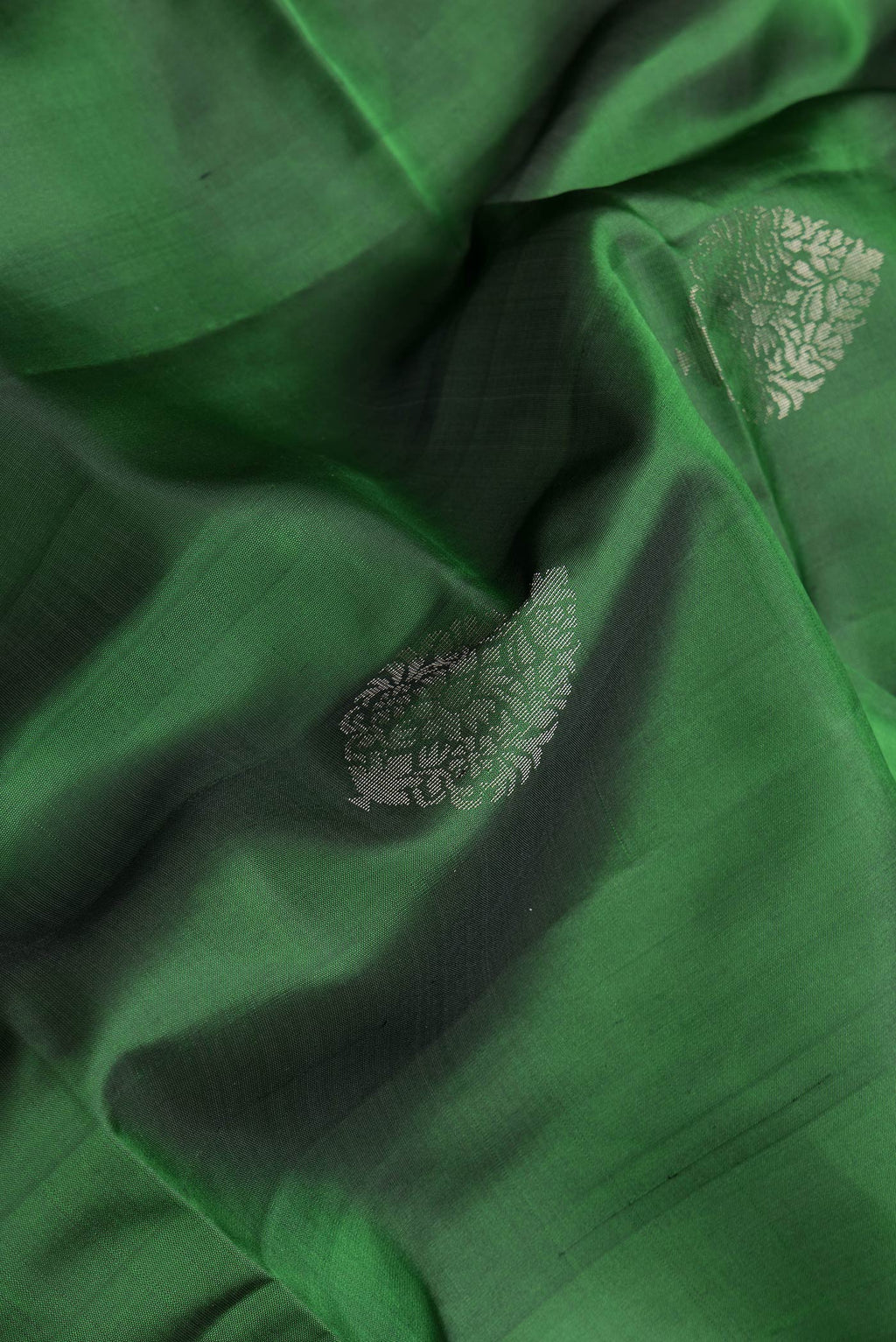 Close up of Bottle Green Dual Tone Soft Silk Saree with Zari Butta on the body and Zari Border.  displaying folds