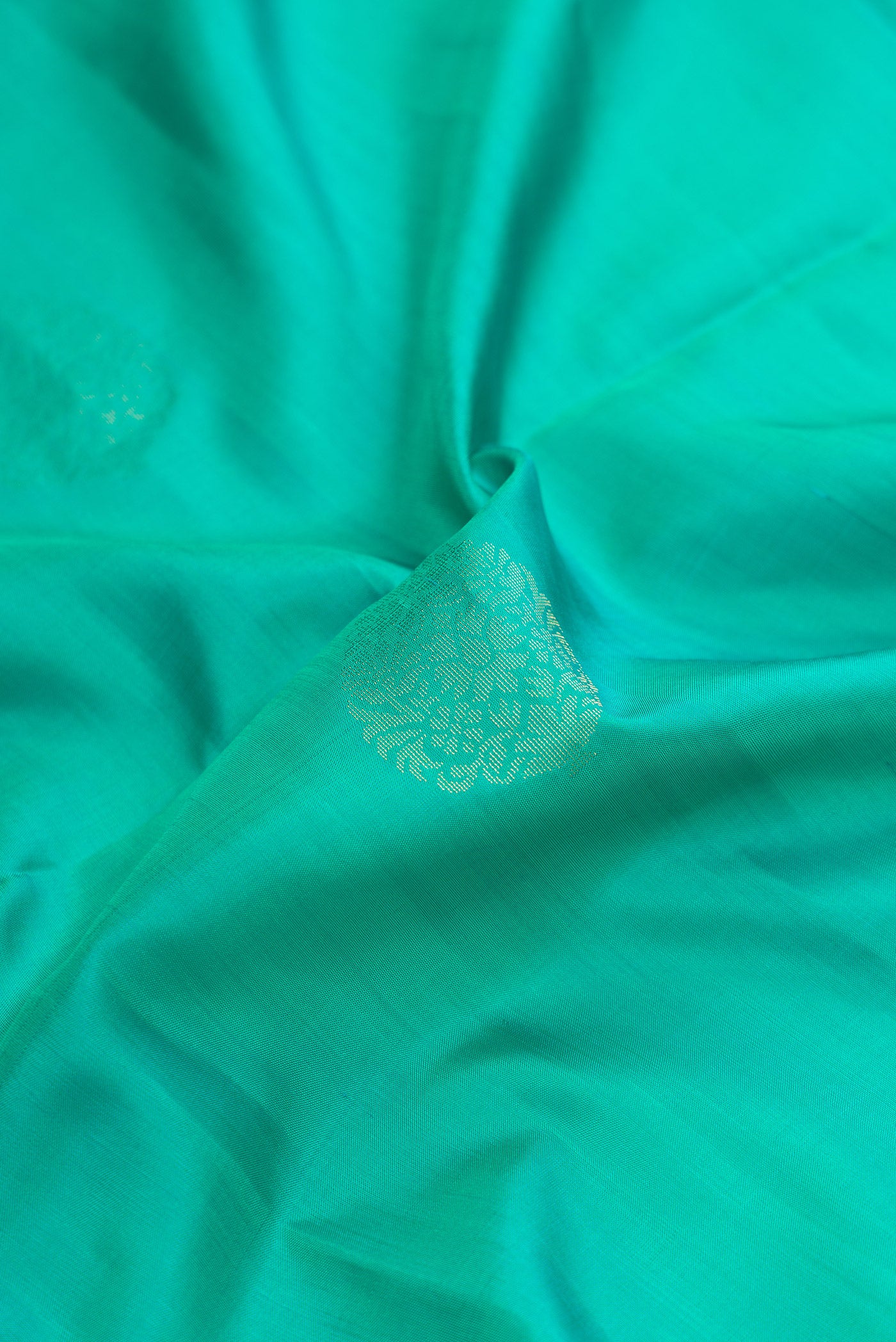 Close up of Sea Green Dual Tone Soft Silk Saree with Zari Butta on the body and Zari Border.  displaying folds