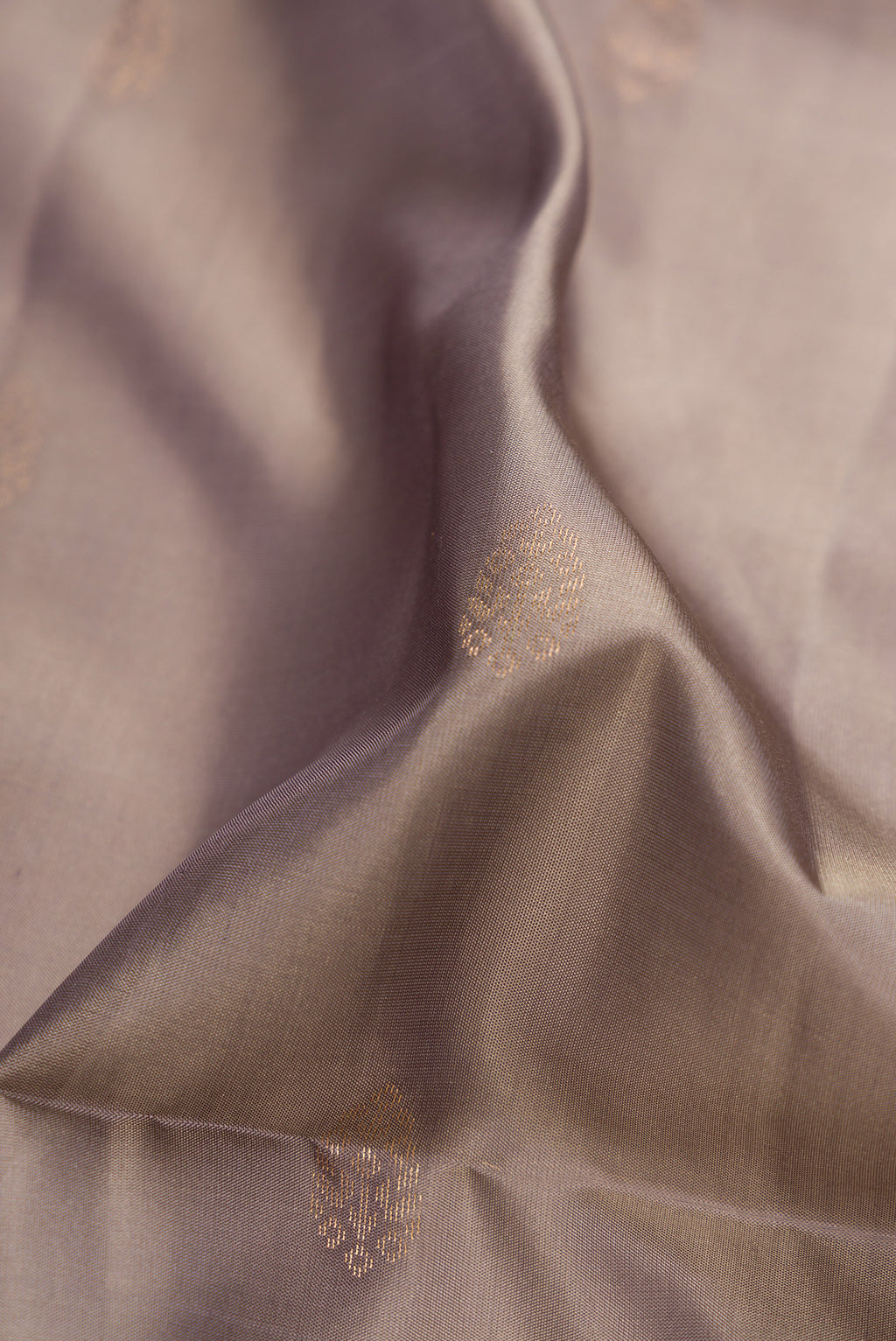 Close up of Grey Dual Tone Soft Silk Saree with Zari Butta on the body and Zari Border.  displaying folds