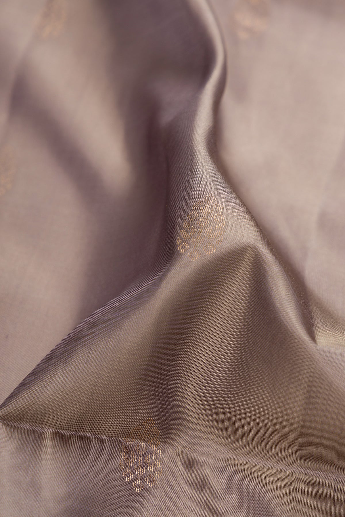 Close up of Grey Dual Tone Soft Silk Saree with Zari Butta on the body and Zari Border.  displaying folds