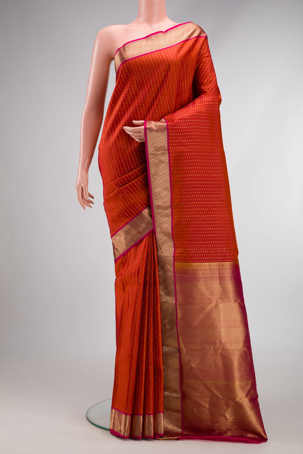 Brick Orange Dual Tone Kanchipuram Silk Saree with Stripes on the body and Zari Border.  displayed on a mannequin