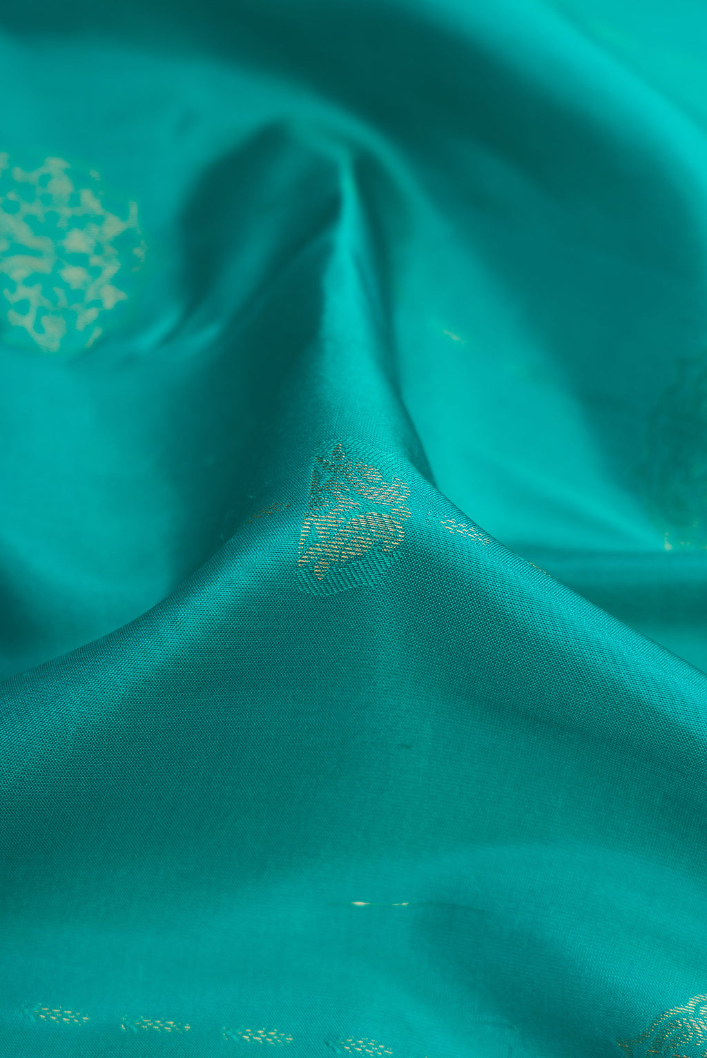 Close up of Sky Blue Kanchipuram Silk Saree with Zari Butta on the body and Zari Border.  displaying folds