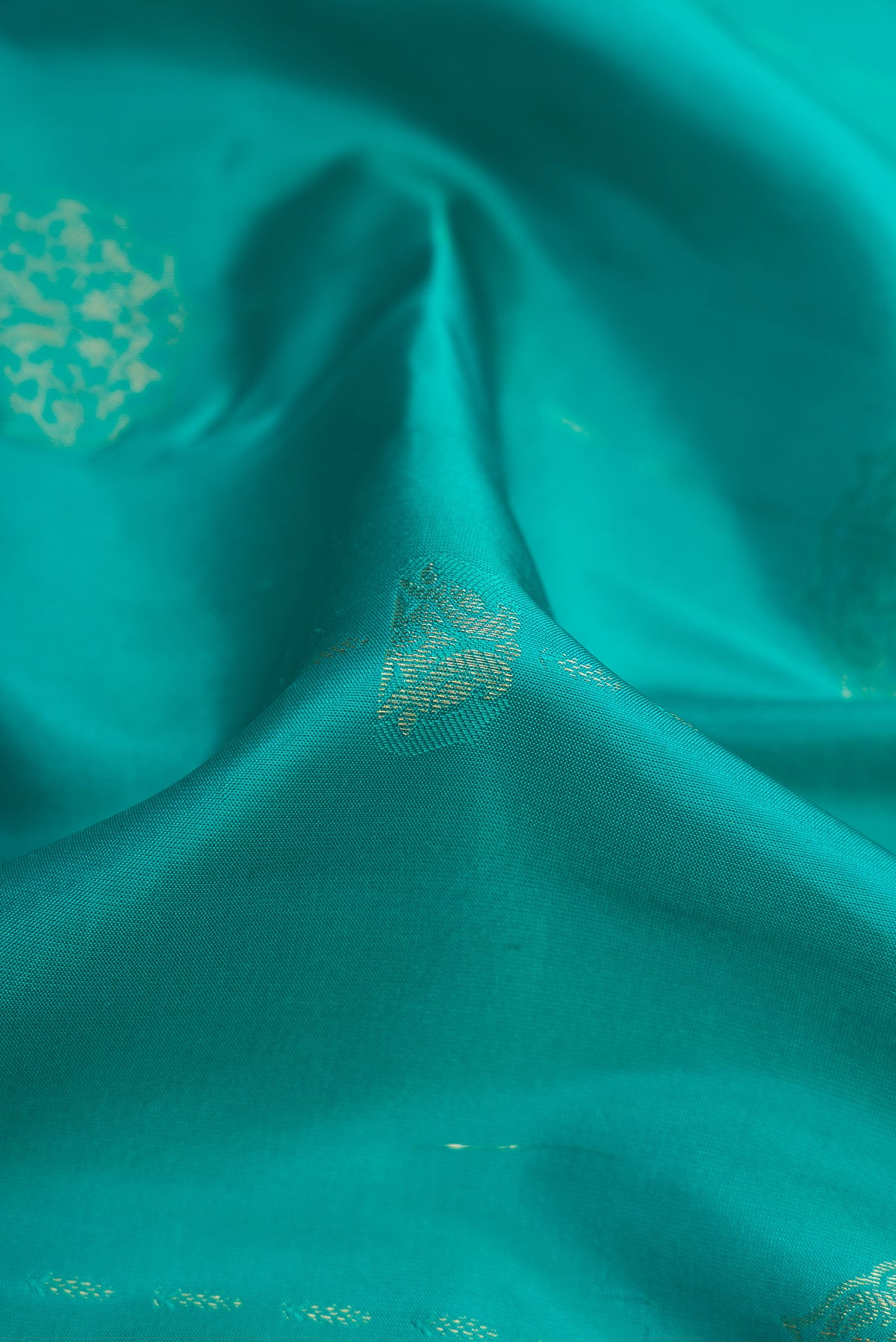 Close up of Sky Blue Kanchipuram Silk Saree with Zari Butta on the body and Zari Border.  displaying folds