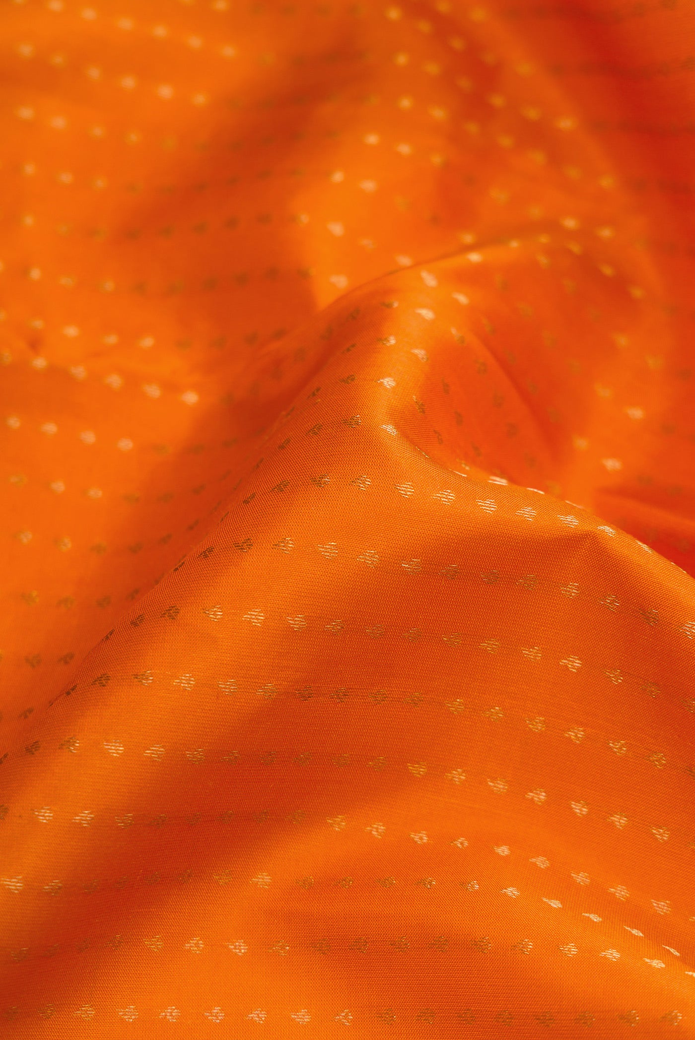 Close up of Orange Dual Tone Kanchipuram Silk Saree with Stripes on the body and Fancy Border.  displaying folds