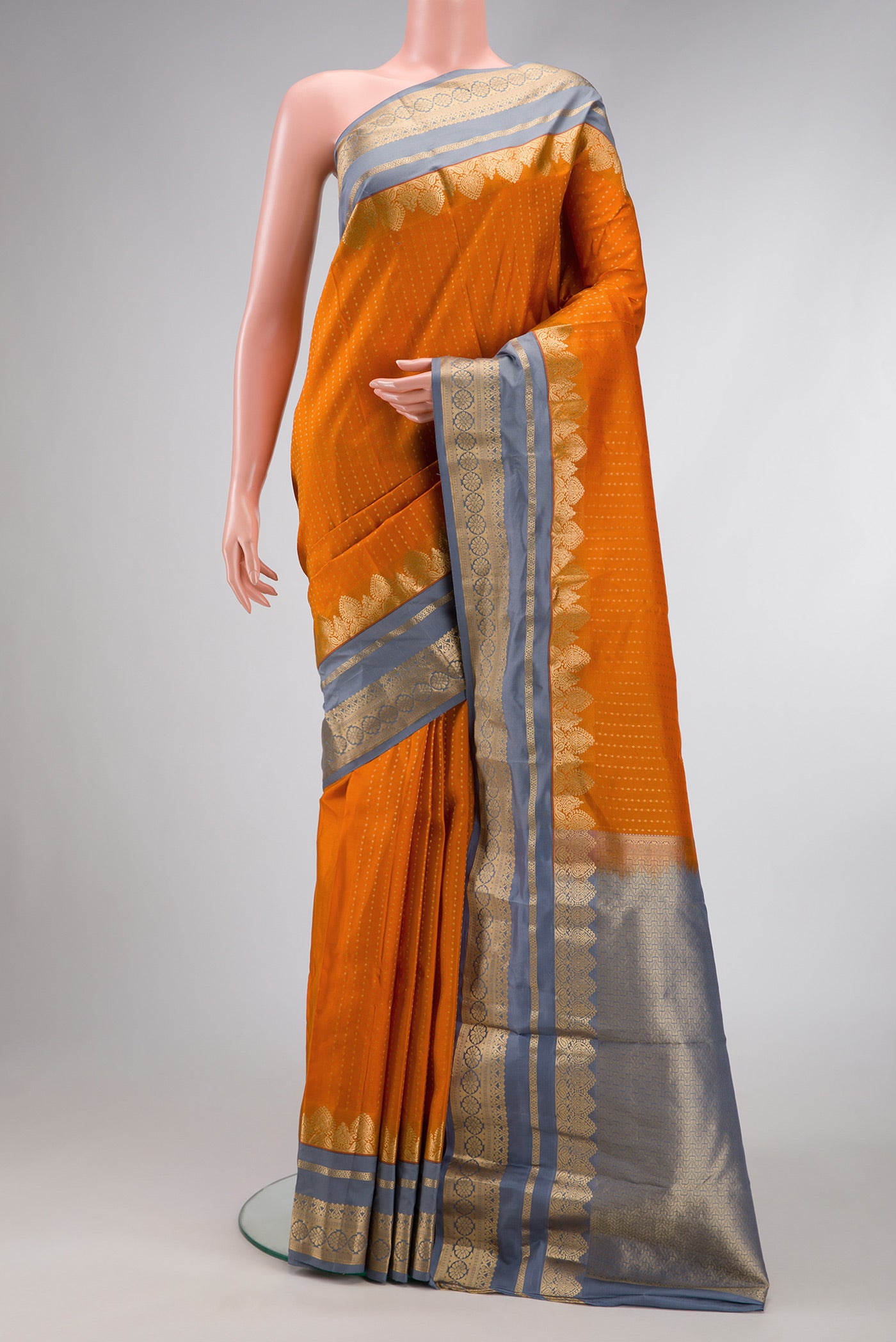 Orange Dual Tone Kanchipuram Silk Saree with Stripes on the body and Fancy Border.  displayed on a mannequin
