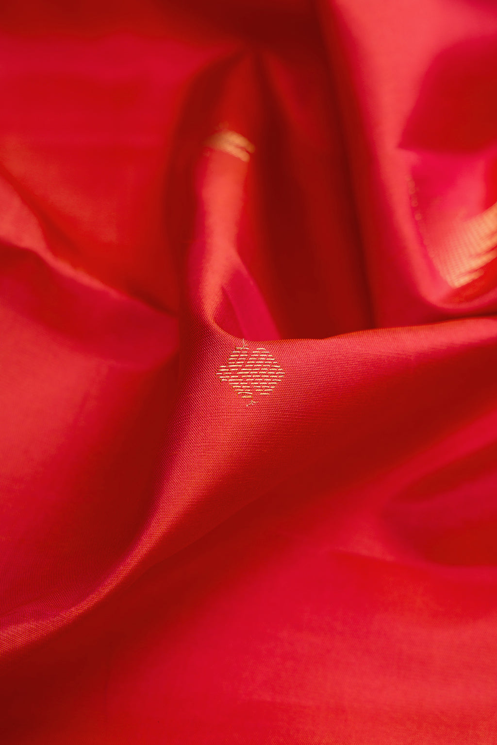 Close up of Brick Orange Dual Tone Kanjivaram Silk Saree with Zari Butta on the body and Fancy Border.  displaying folds