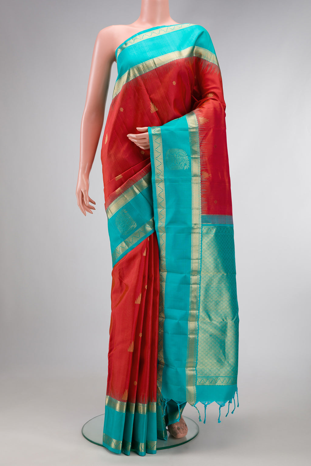 Brick Orange Dual Tone Kanjivaram Silk Saree with Zari Butta on the body and Fancy Border.  displayed on a mannequin