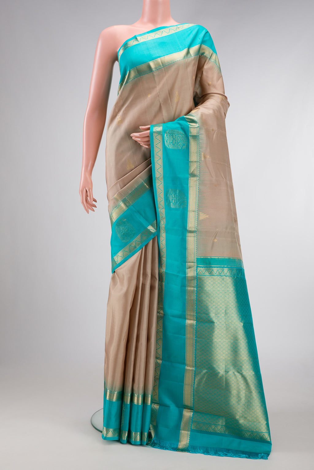 Beige Dual Tone Kanjivaram Silk Saree with Zari Butta on the body and Fancy Border.  displayed on a mannequin