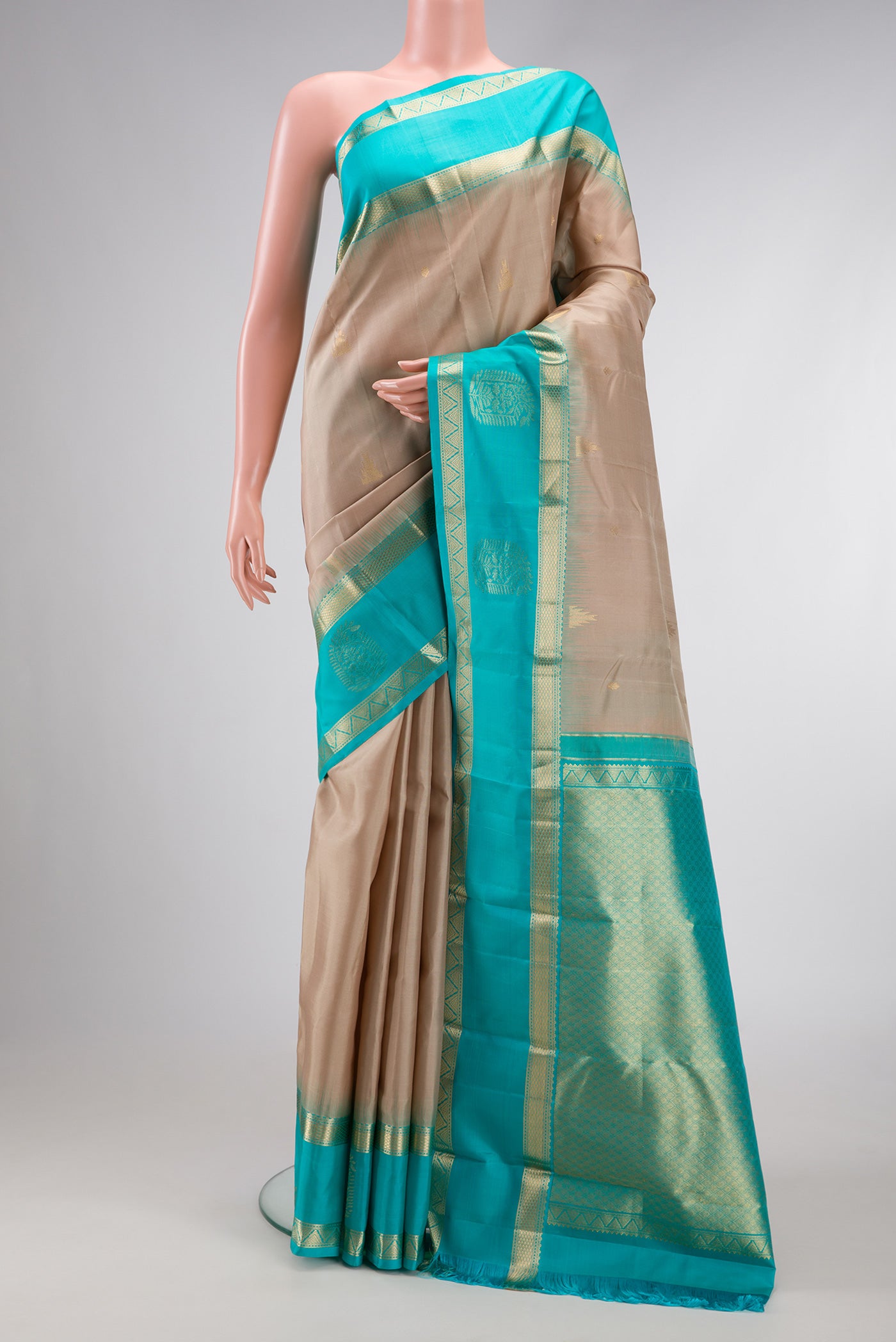 Beige Dual Tone Kanjivaram Silk Saree with Zari Butta on the body and Fancy Border.  displayed on a mannequin