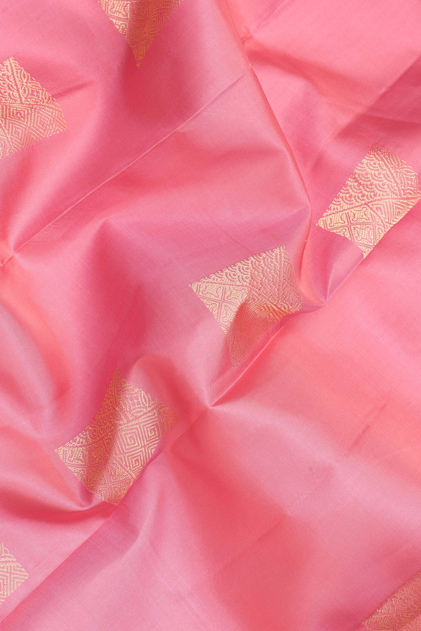 Close up of Pink Kanchipuram Silk Saree with Zari Butta on the body and Zari Border.  displaying folds