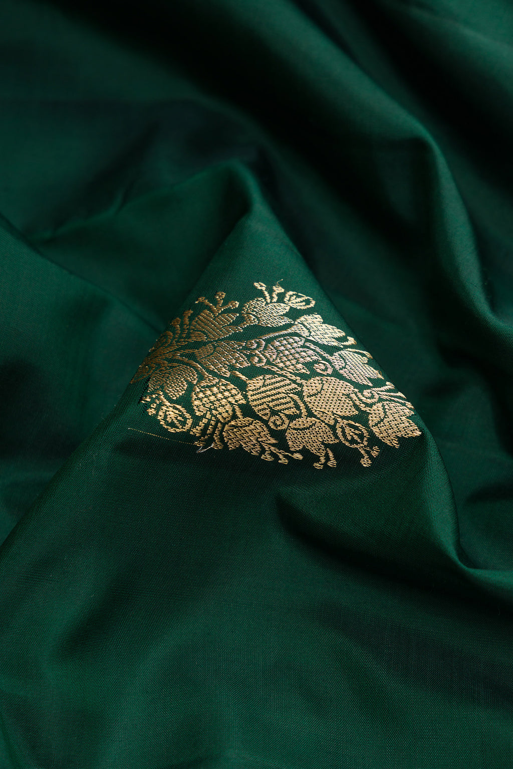 Close up of Bottle Green Dual Tone Kanjivaram Silk Saree with Zari Butta on the body and Zari Border.  displaying folds