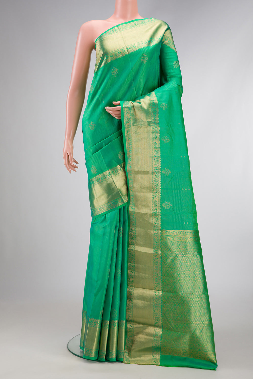 Green Dual Tone Kanjivaram Silk Saree with Zari Butta on the body and Zari Border.  displayed on a mannequin