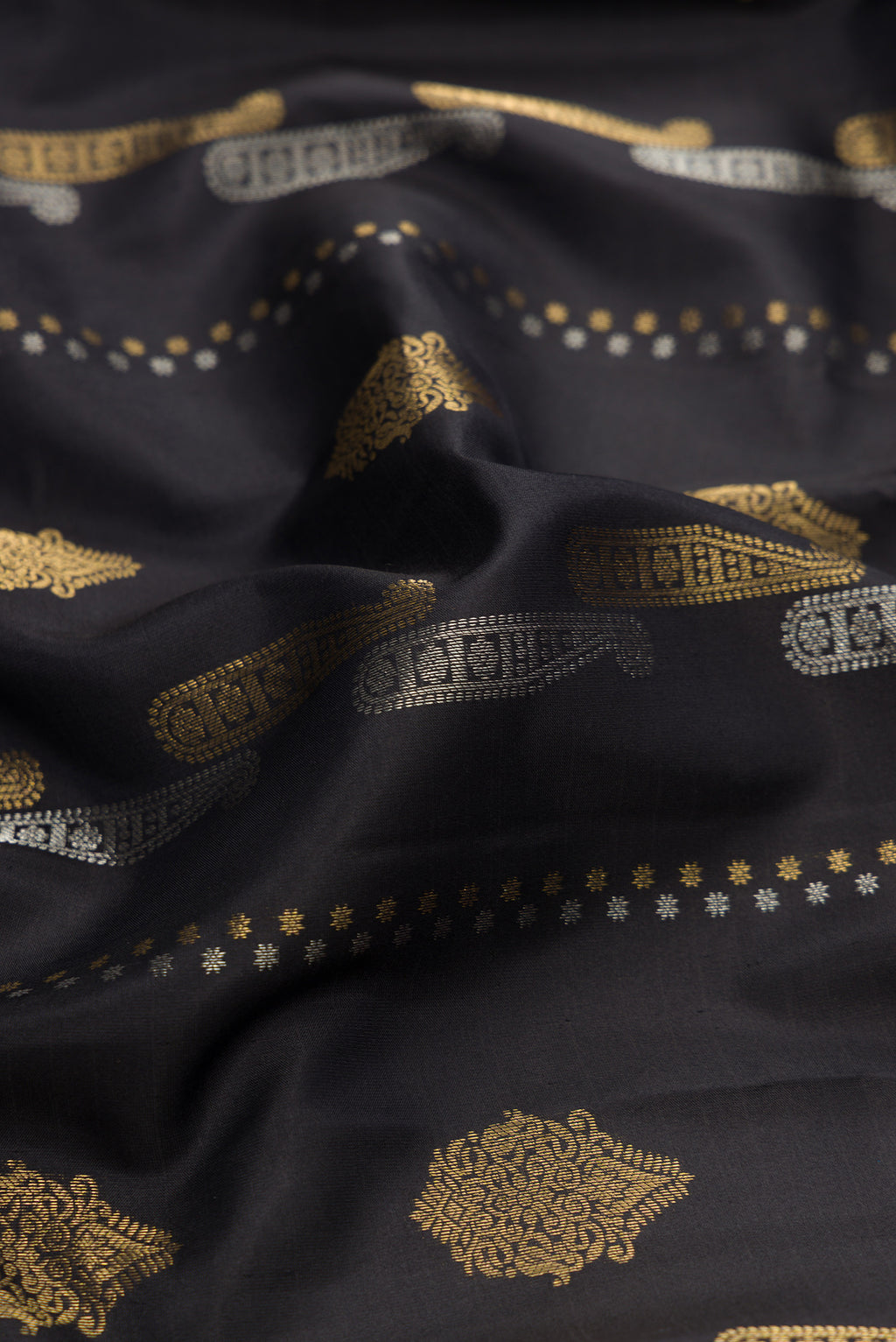 Close up of Black Dual Tone Kanjivaram Silk Saree with Zari Butta on the body and Zari Border.  displaying folds