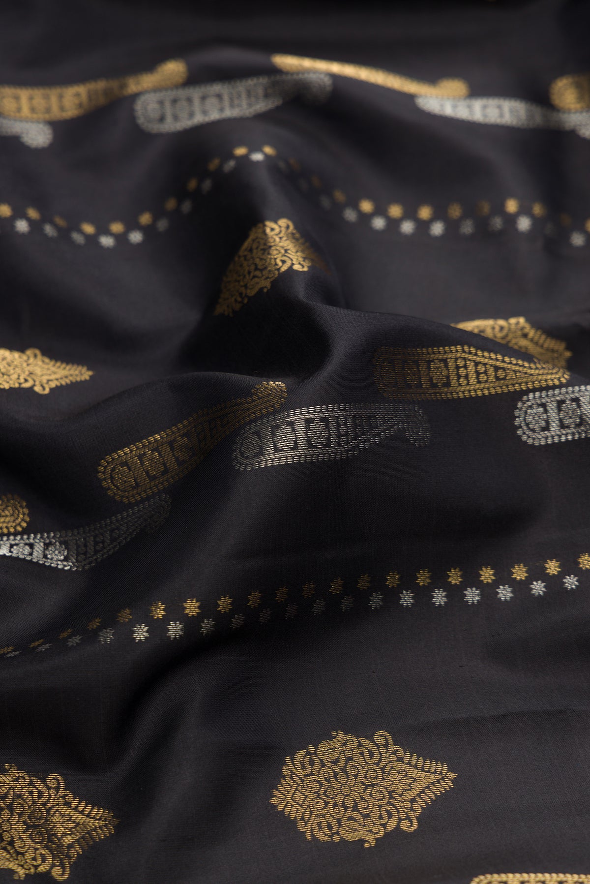 Close up of Black Dual Tone Kanjivaram Silk Saree with Zari Butta on the body and Zari Border.  displaying folds