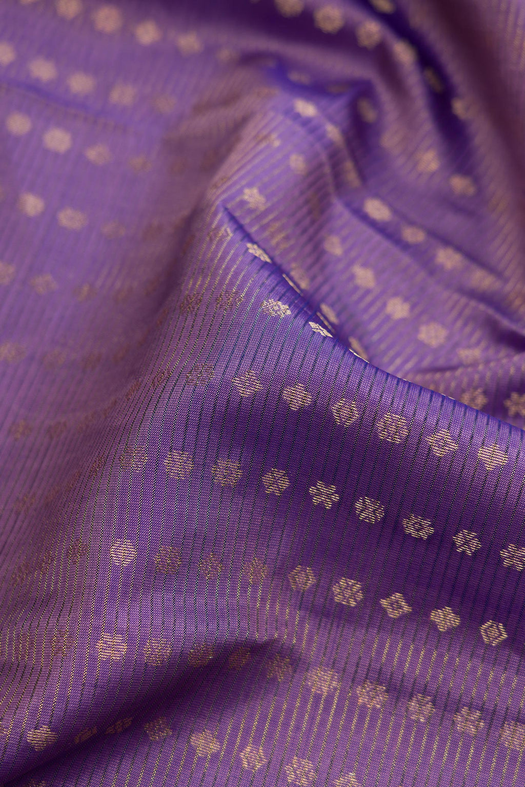 Close up of Purple Dual Tone Kanchipuram Silk Saree with Stripes on the body and Plain Border.  displaying folds