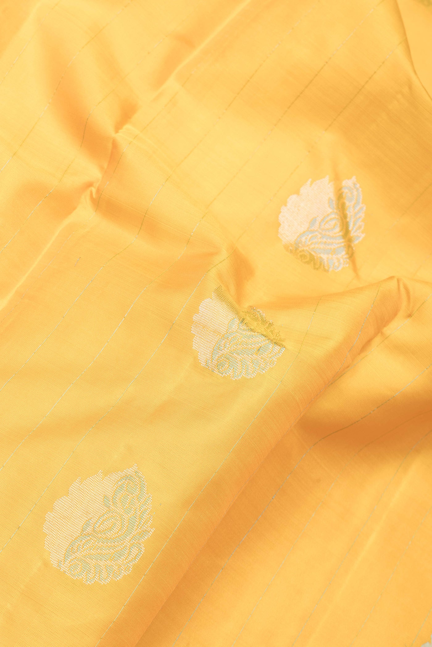 Close up of Yellow Dual Tone Kanchipuram Silk Saree with Stripes on the body and Fancy Border.  displaying folds
