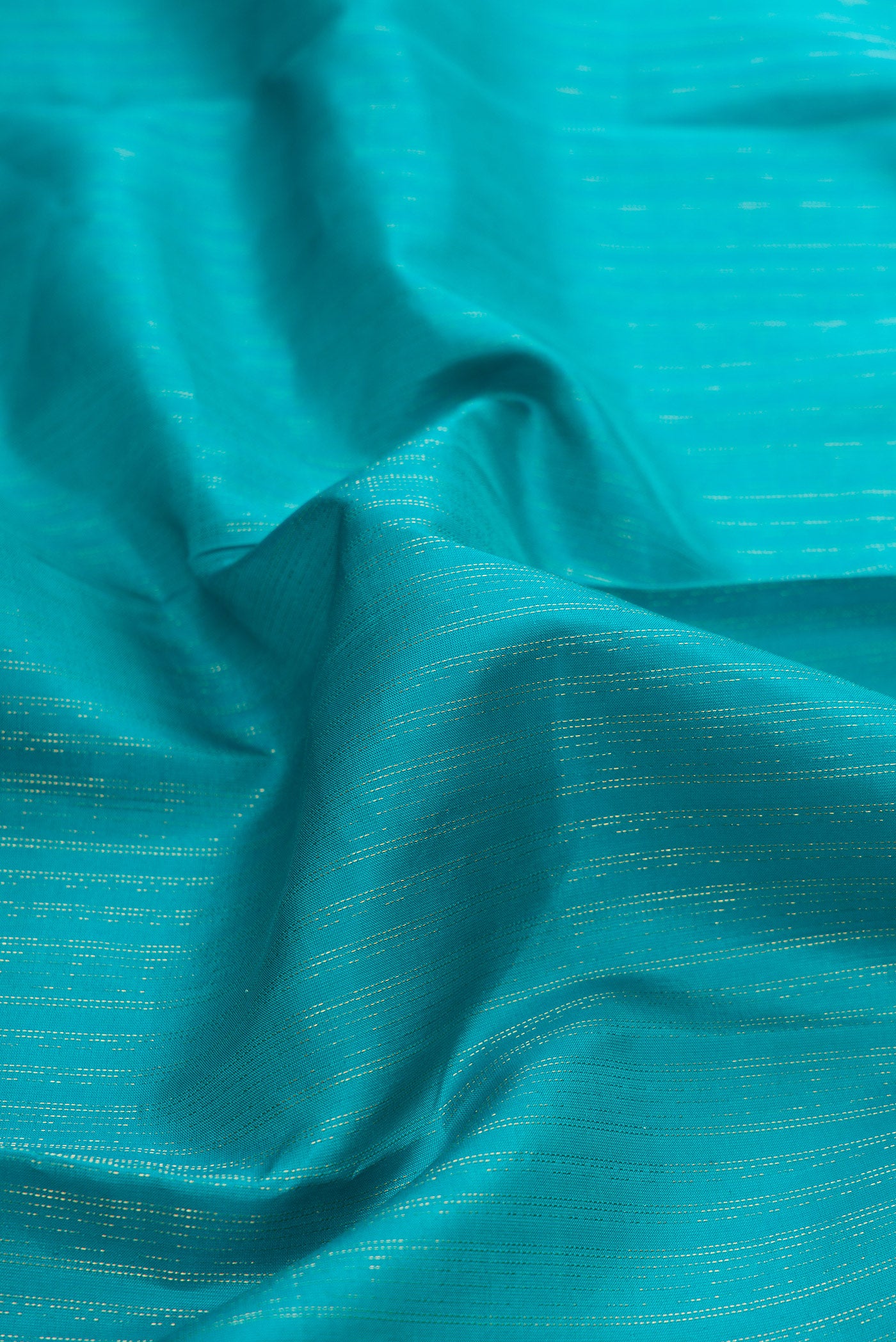Close up of Sky Blue Dual Tone Kanchipuram Silk Saree with Stripes on the body and Zari And Thread Border.  displaying folds
