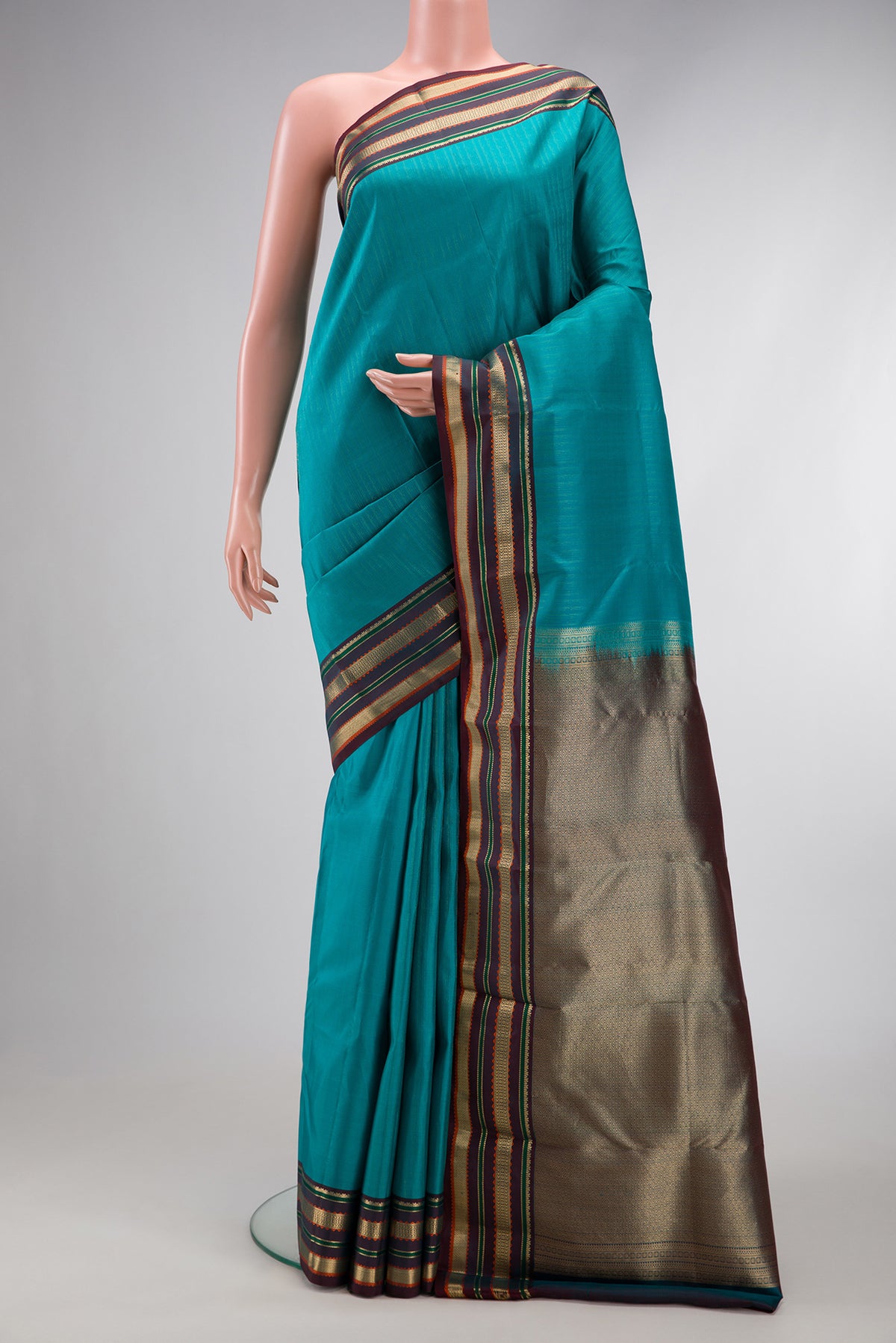 Sky Blue Dual Tone Kanchipuram Silk Saree with Stripes on the body and Zari And Thread Border.  displayed on a mannequin