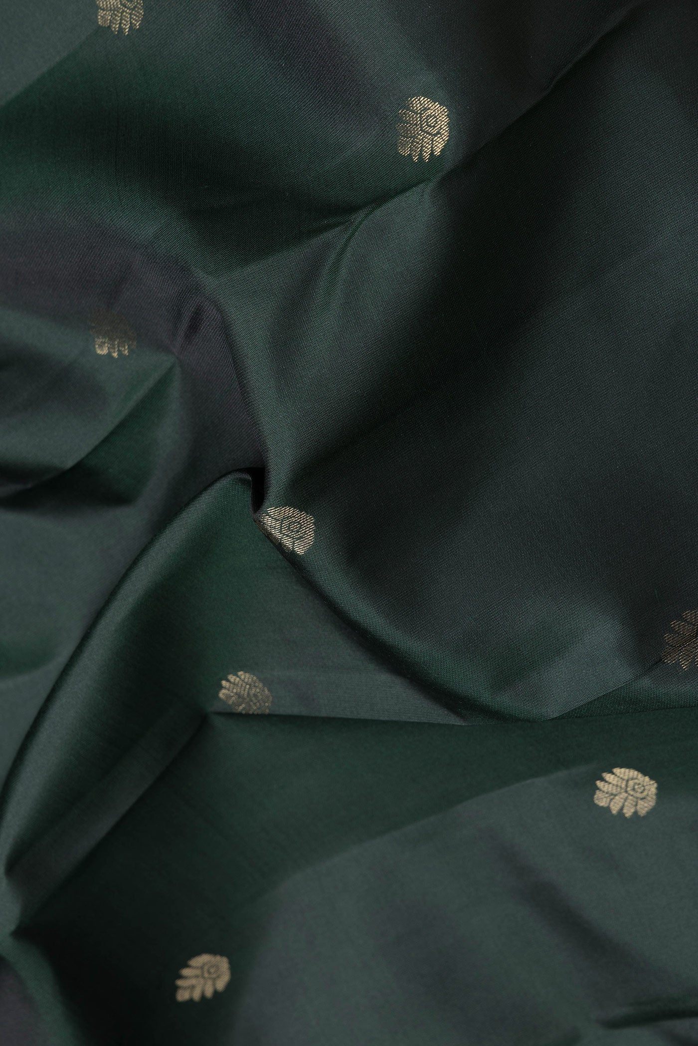 Close up of Bottle Green Dual Tone Kanchipuram Silk Saree with Zari Butta on the body and Zari Border.  displaying folds