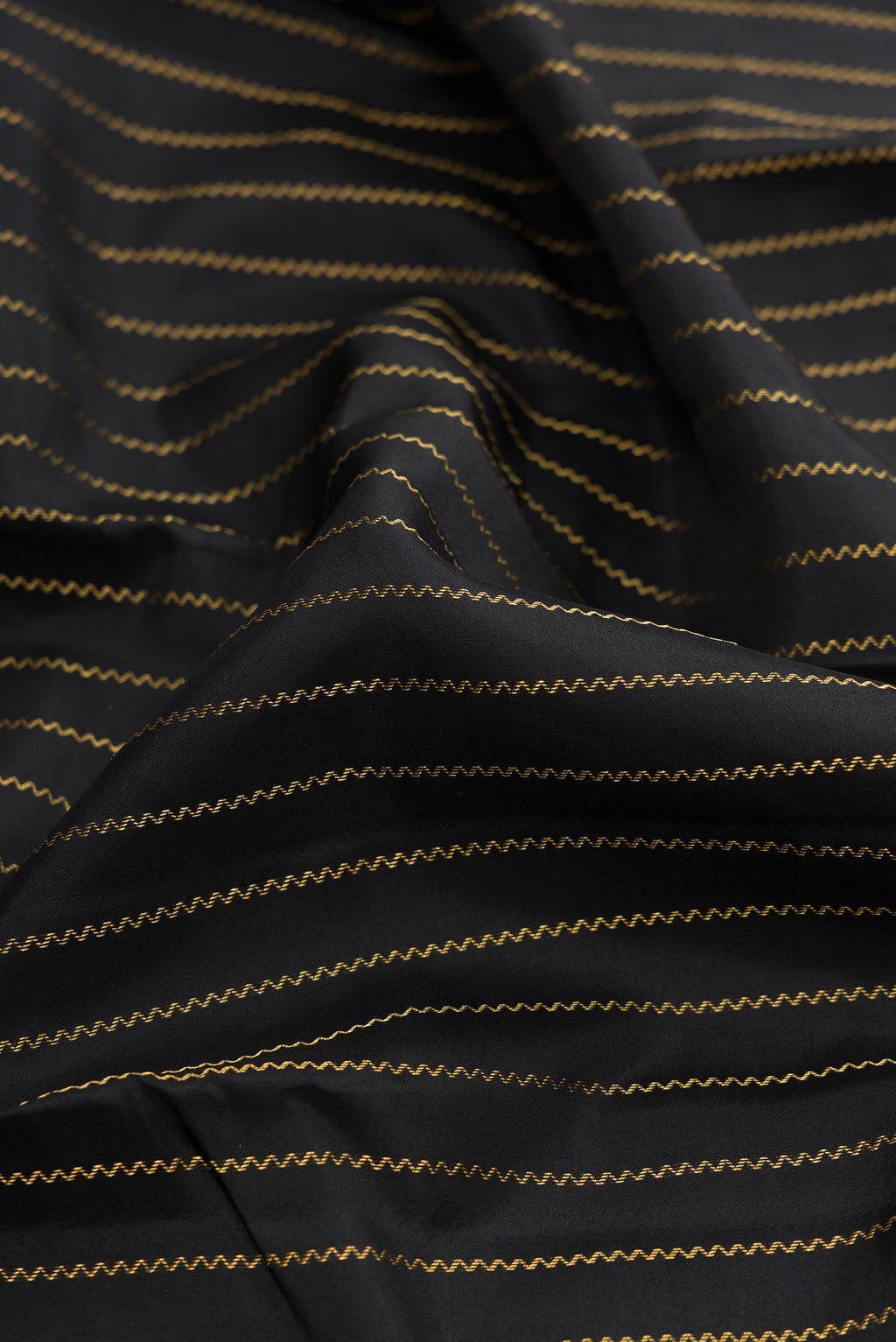 Close up of Black Dual Tone Kanchipuram Silk Saree with Stripes on the body and Fancy Border.  displaying folds